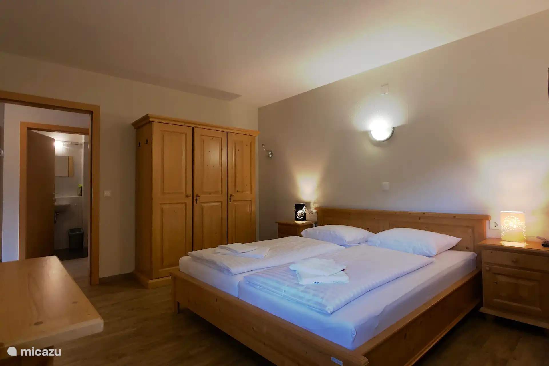 Slaapkamer met twee persoonsbed, stapelbed en eigen badkamer.