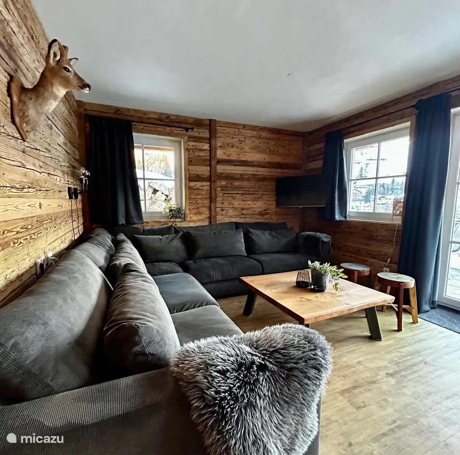 Woonkamer met uitzicht op de tuin en het dal. Open keuken met eettafel.