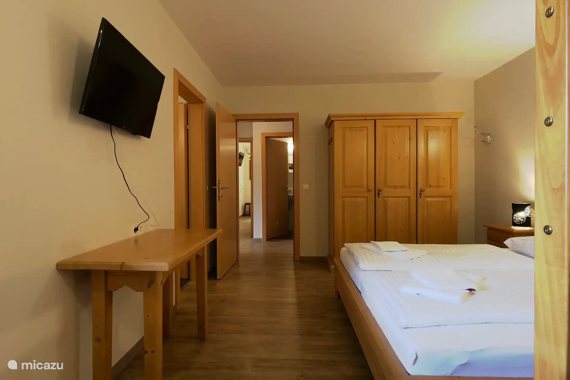 Slaapkamer met twee persoonsbed, stapelbed en eigen badkamer.