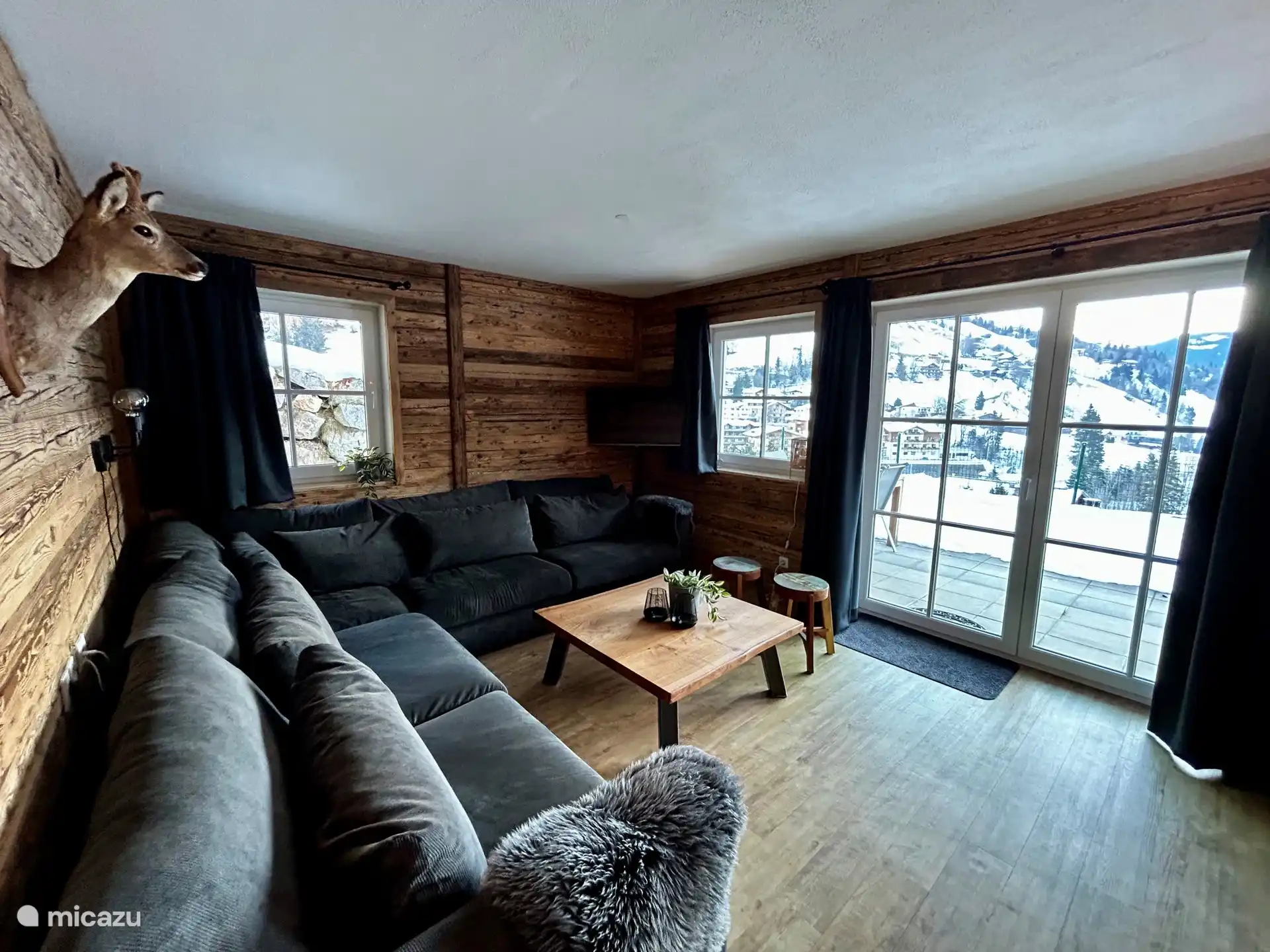 Woonkamer met uitzicht op de tuin en het dal. Open keuken met eettafel.