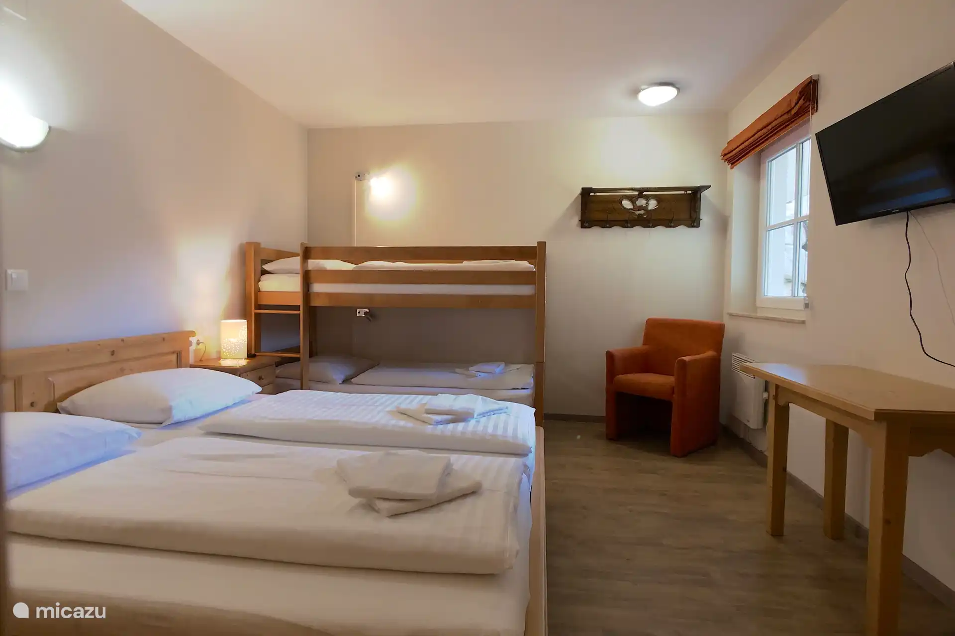 Slaapkamer met twee persoonsbed, stapelbed en eigen badkamer.