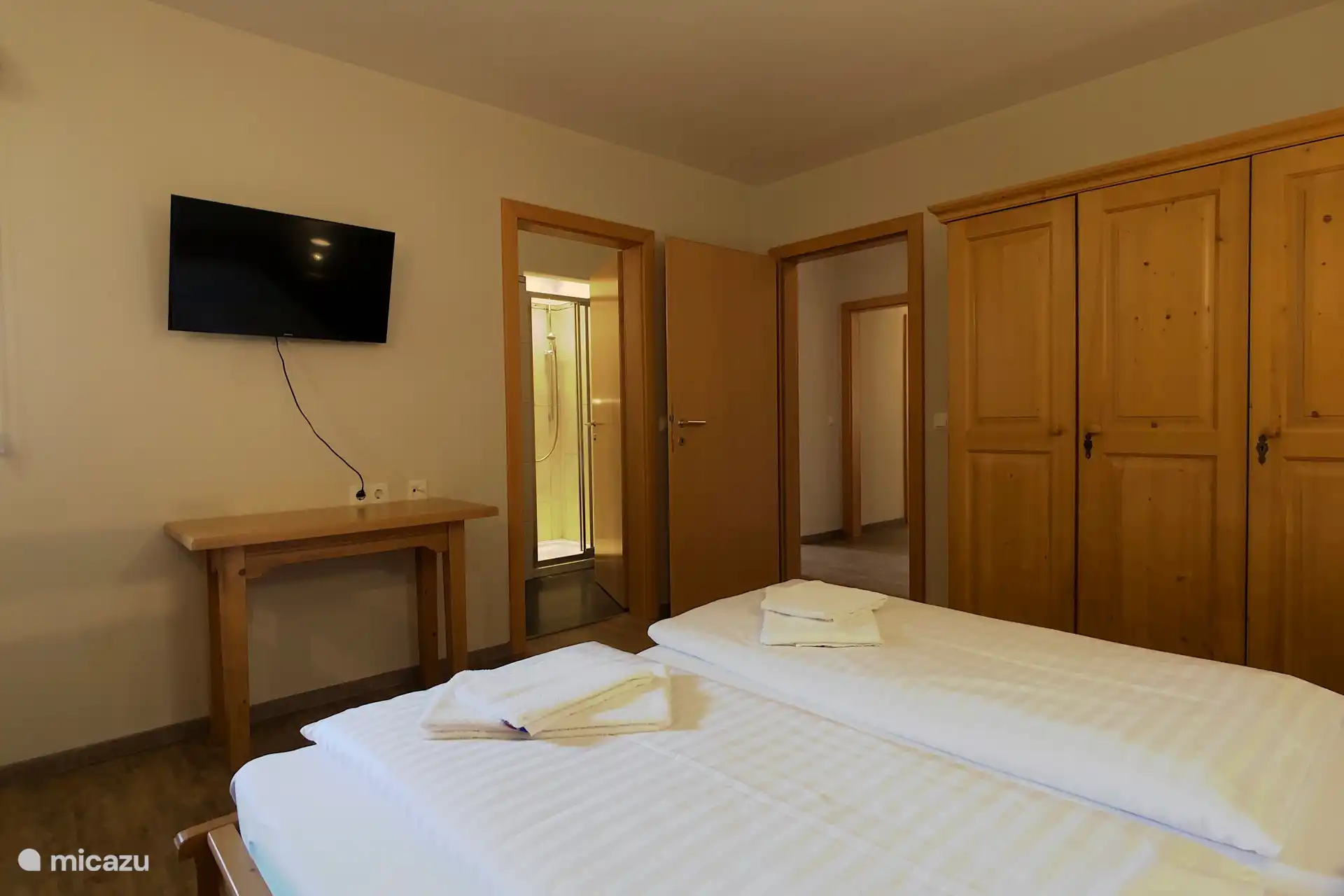 Slaapkamer met twee persoonsbed, stapelbed en eigen badkamer.