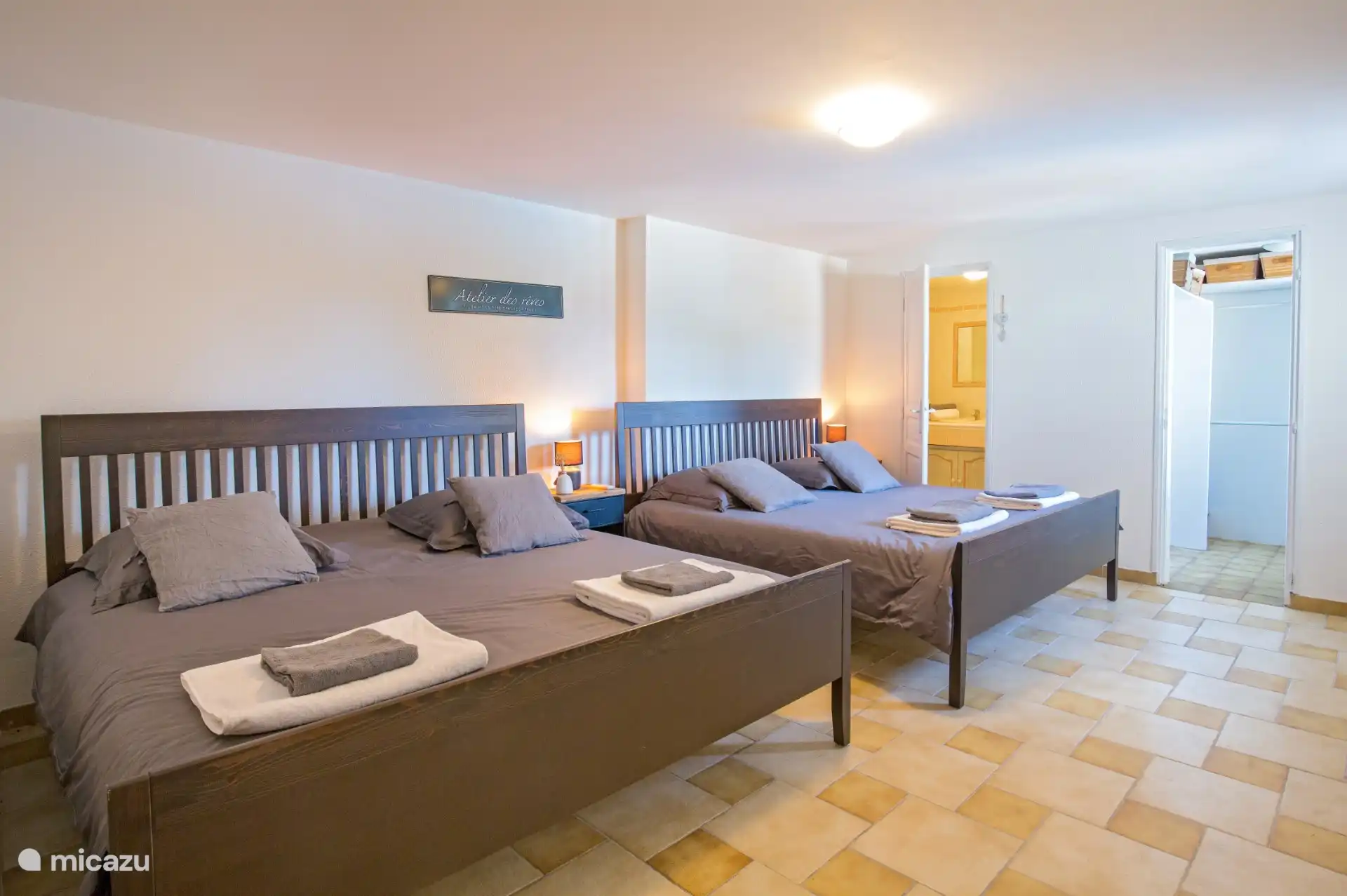 La chambre du rez-de-chaussée avec deux lits king size, salle de bain privée et accès à la piscine et à la salle de jeux