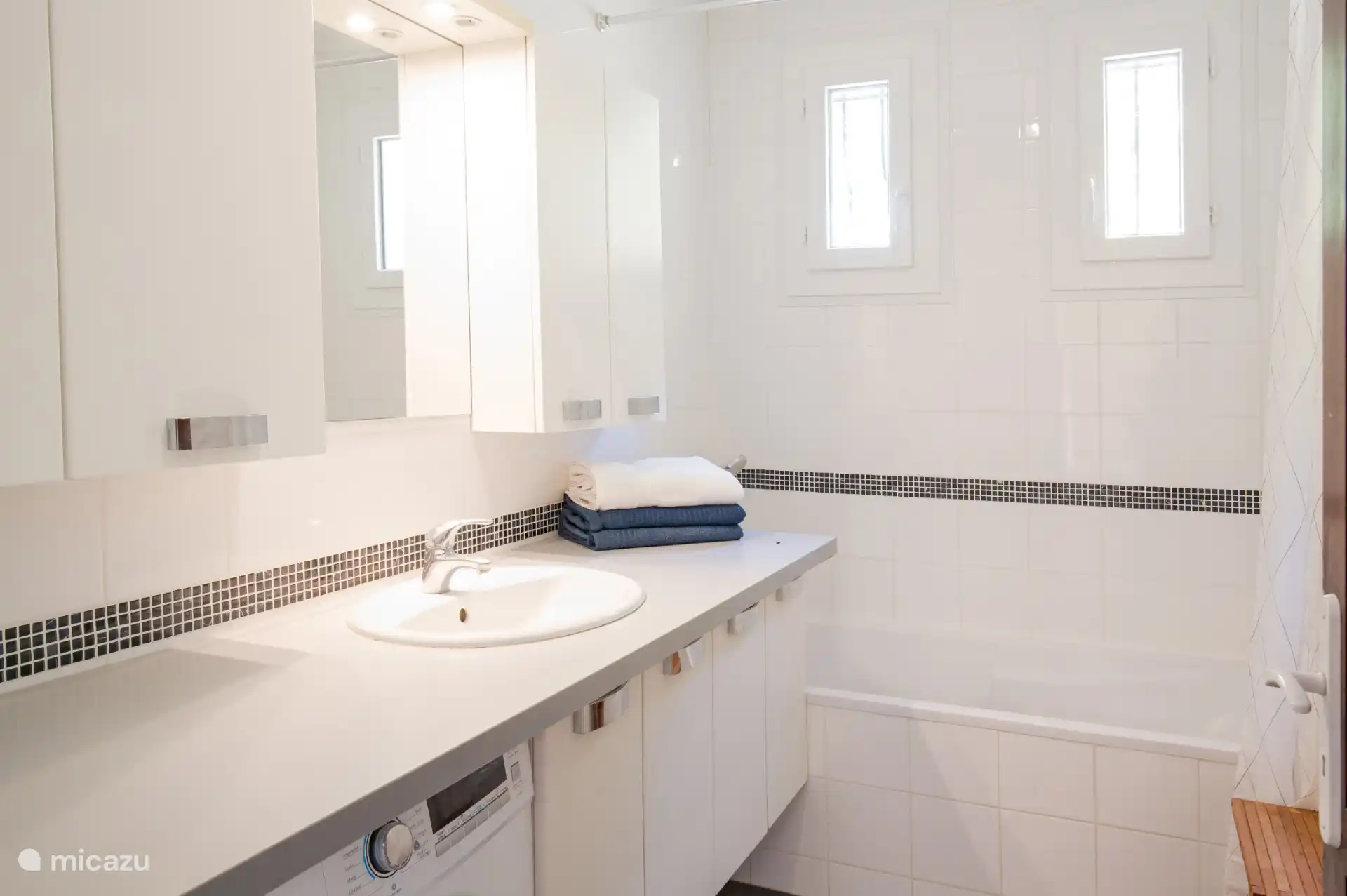 La salle de bain en tweed au rez-de-chaussée avec douche et baignoire. Ici aussi une machine à laver