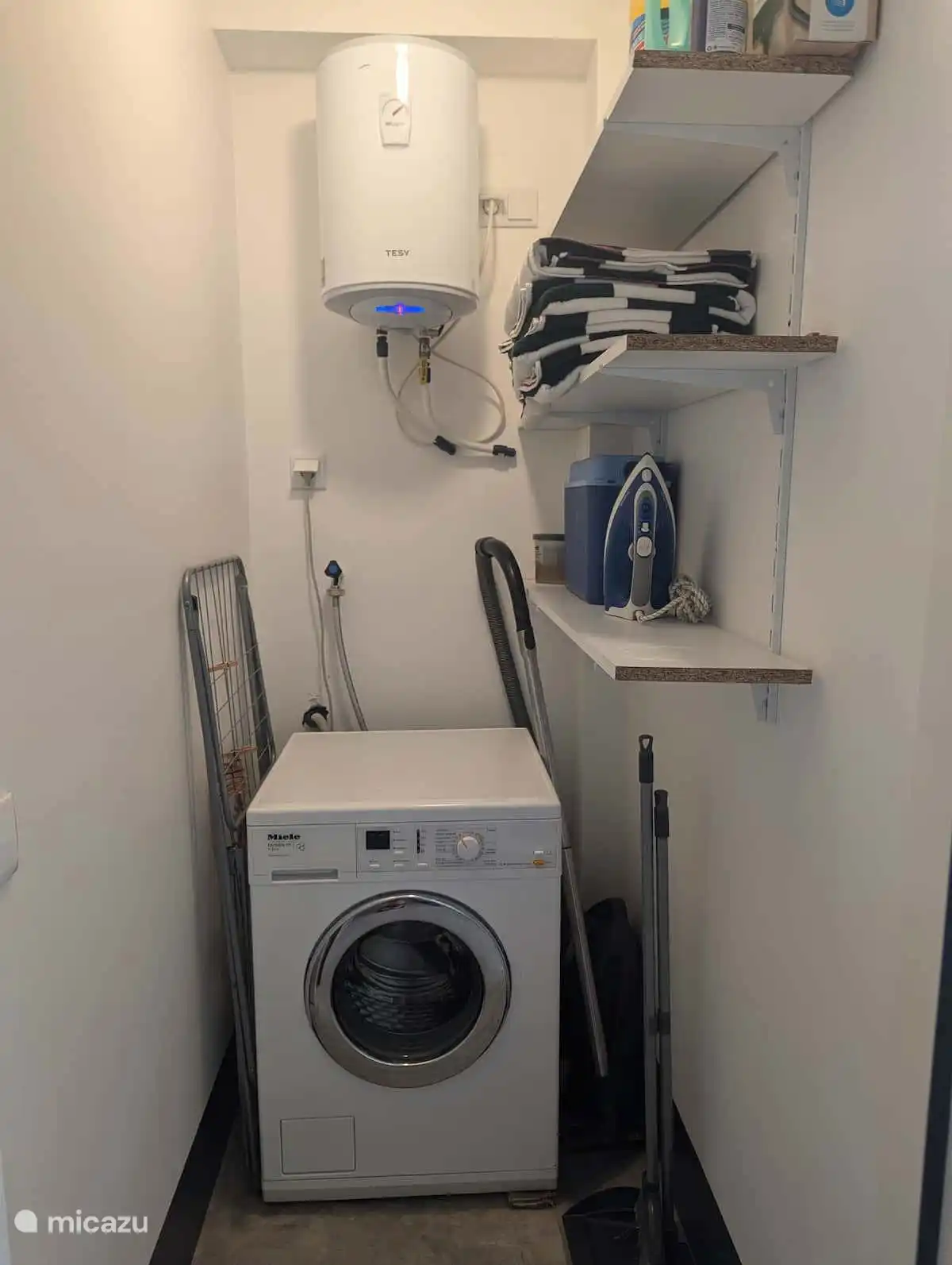Waschraum mit Waschmaschine, Bügeleisen und Bügelbrett.