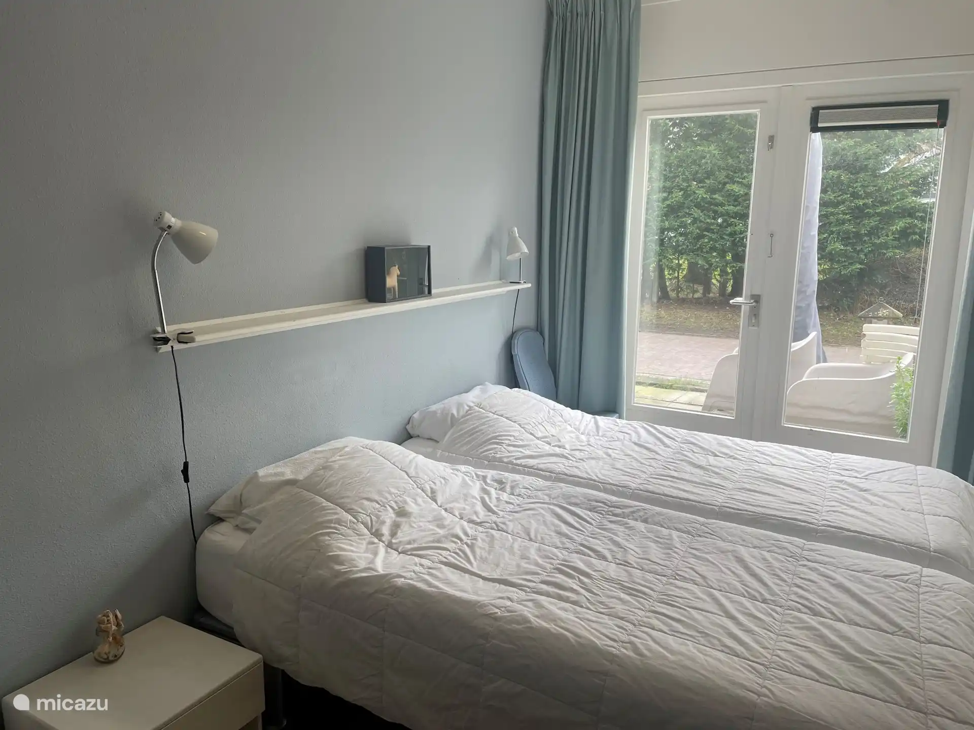 slaapkamer met openslaande deuren naar het terras en toegang tot de eigen badkamer.