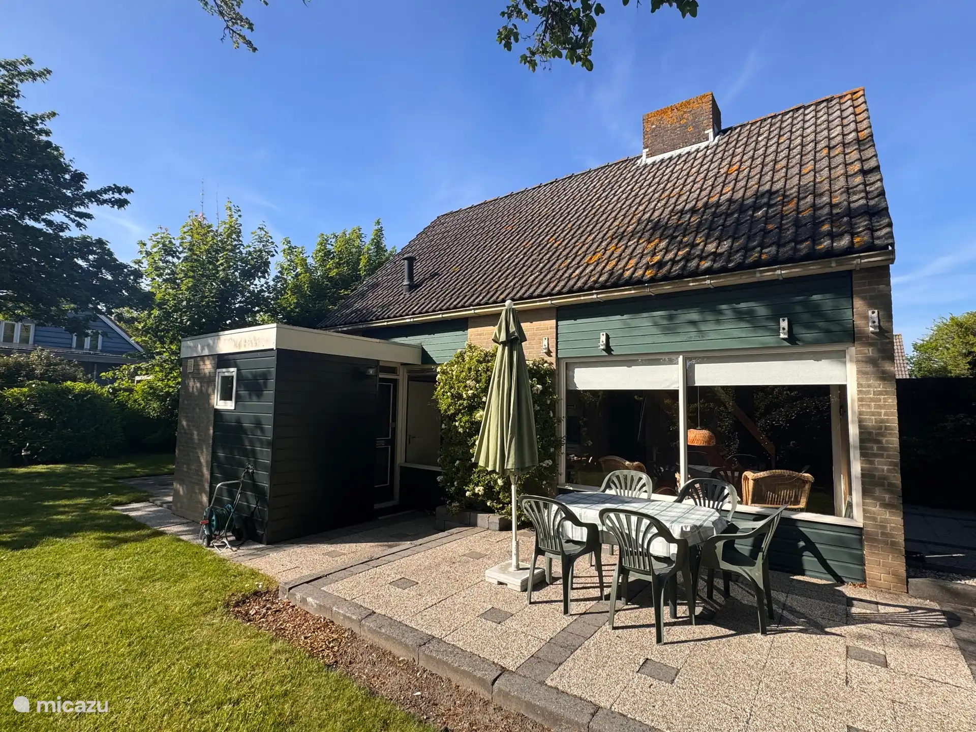 Het terras en de tuin aan de zijkant van het huisje.