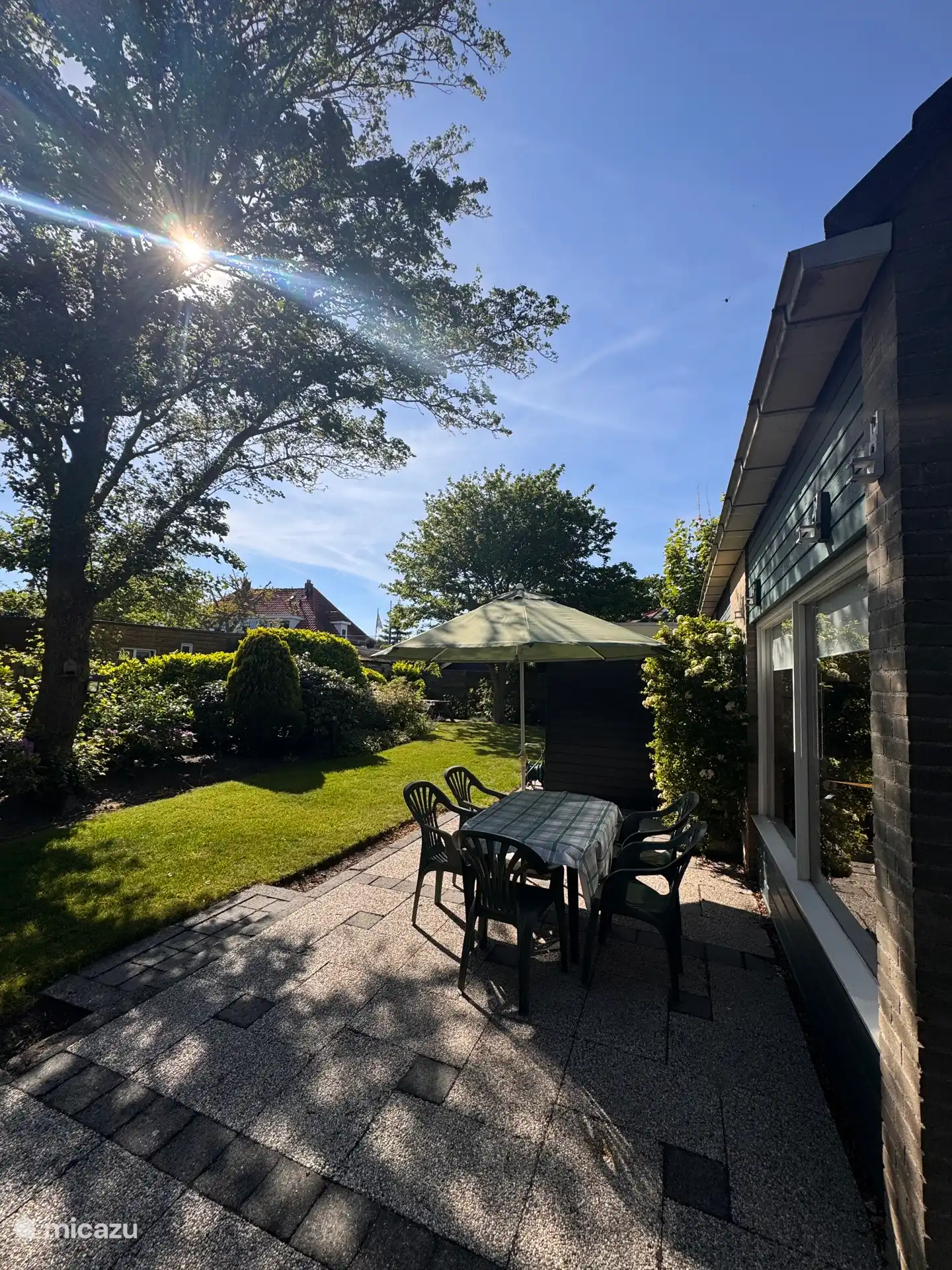 Het terras en de tuin aan de zijkant van het huisje.