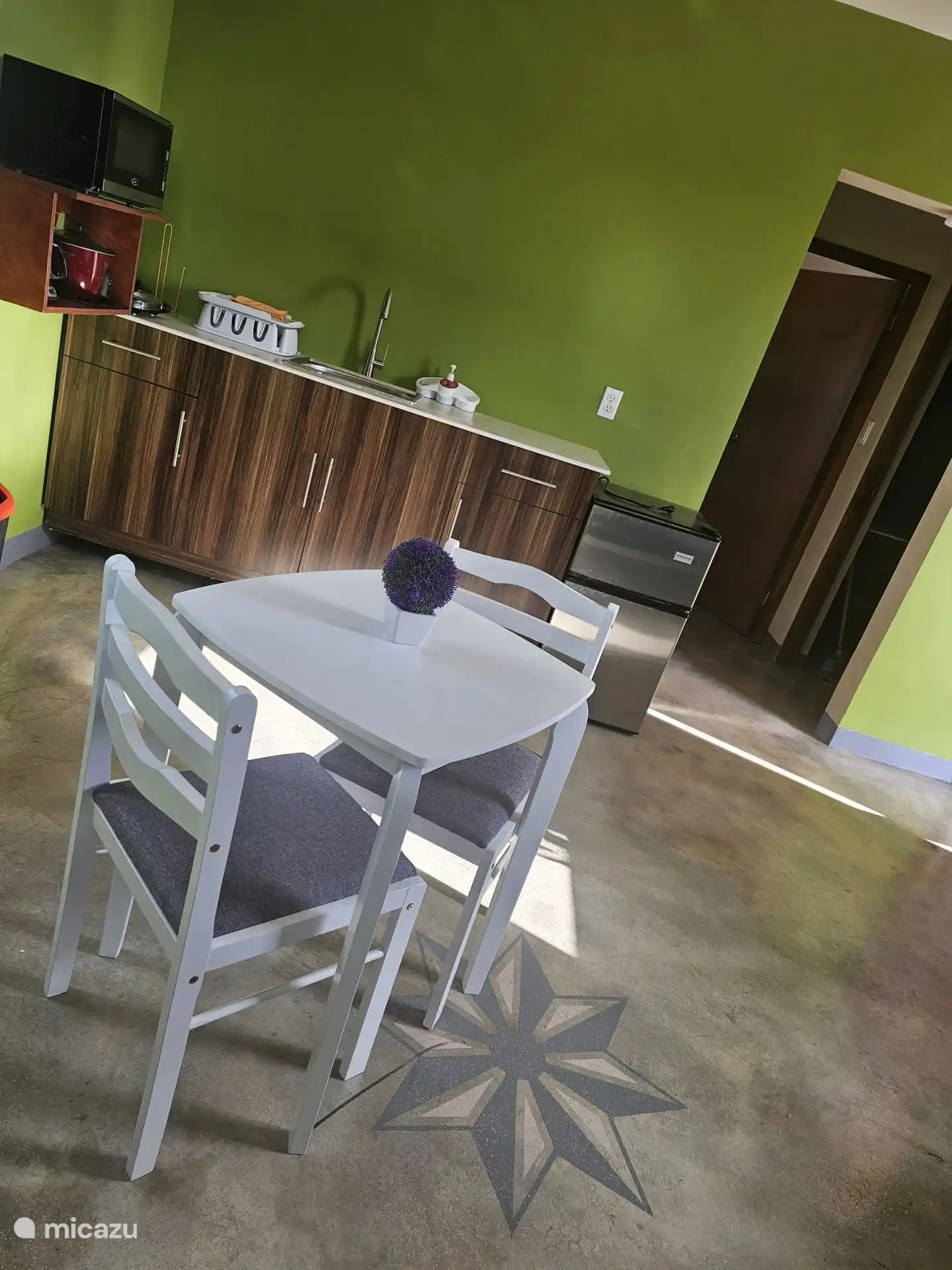 Kitchenette avec appareils de cuisine, réfrigérateur, cuisinière et vaisselle. 
