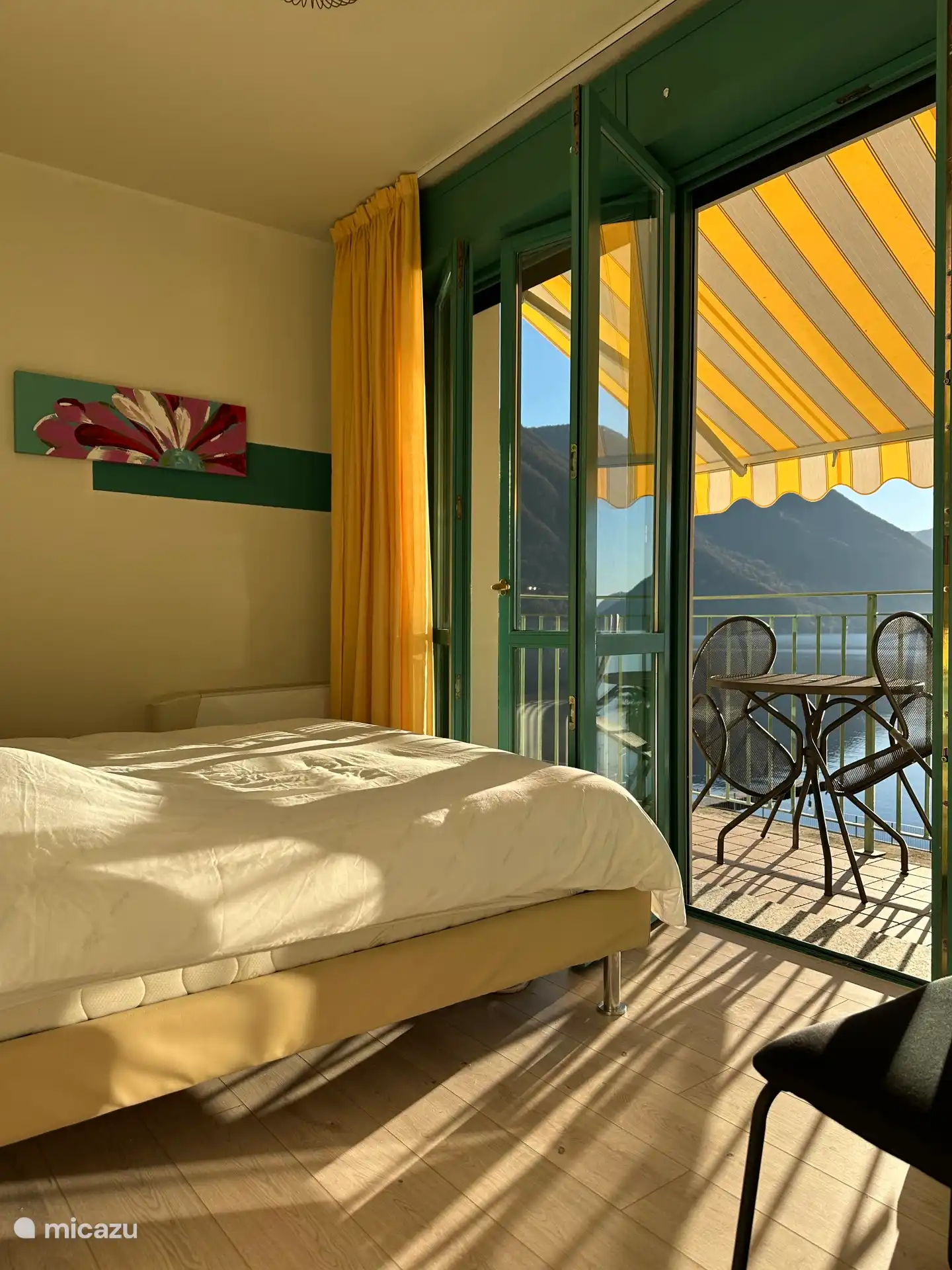 Chambre avec lit double, armoire et porte double patio donnant sur le balcon.