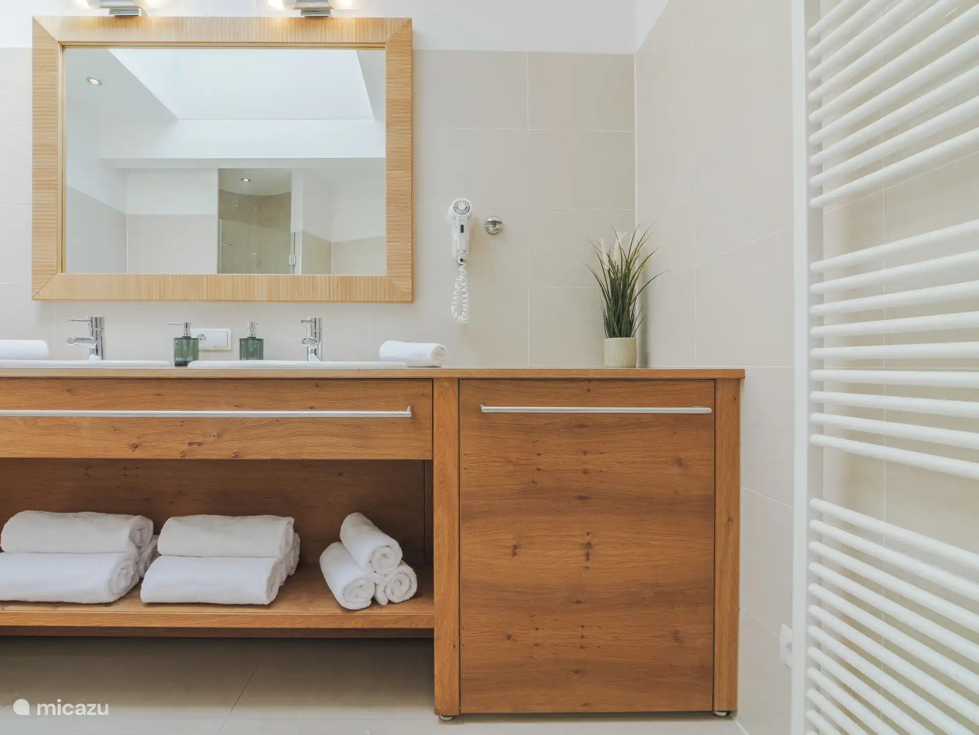 Badkamer met douche, bad en toilet. Er is ook een apart toilet in het appartement.