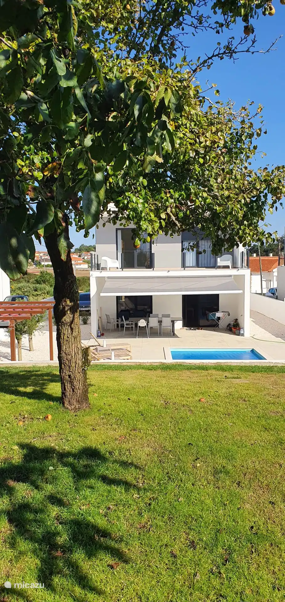 Gezellige tuin met zicht op het zwembad en terras dat deels overdekt kan worden met electronische luifel.