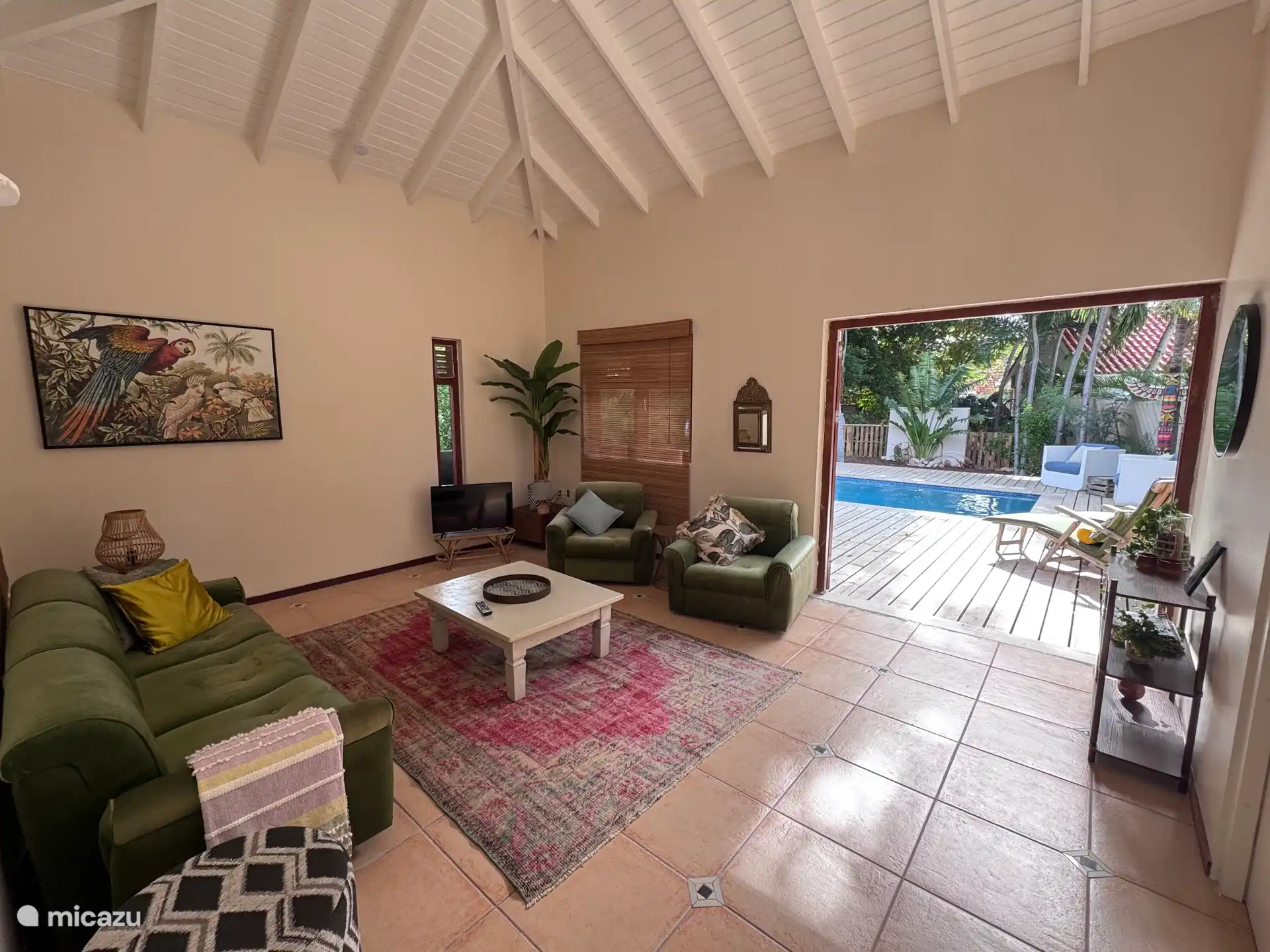 El salón tiene puertas de patio que dan a la zona de la piscina. Con los techos altos y los ventiladores, ¡se siente maravillosamente tropical!
