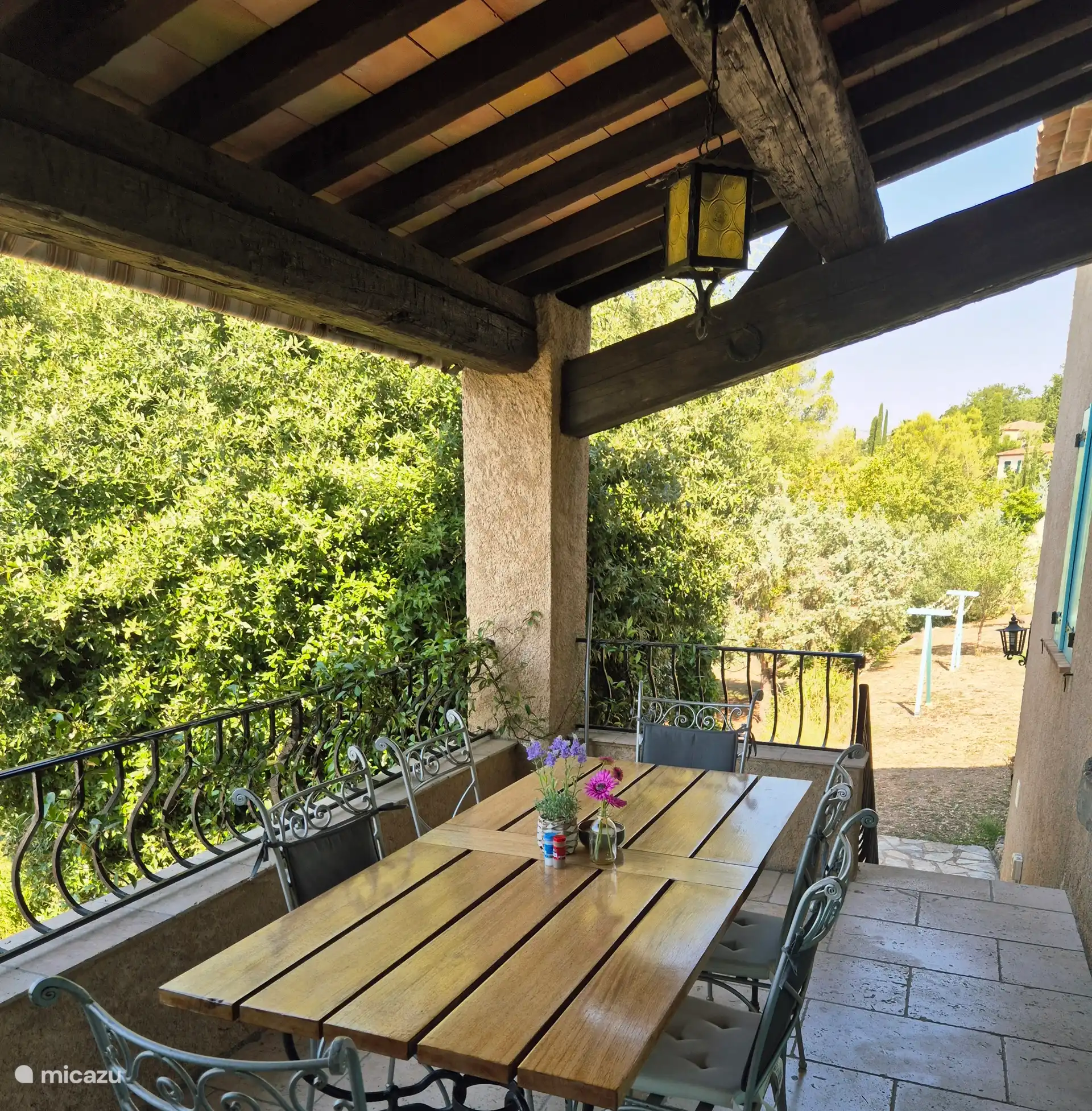 Terrasse avec balcon accessible depuis le salon et la cuisine. Avec des escaliers en pierre menant au jardin.