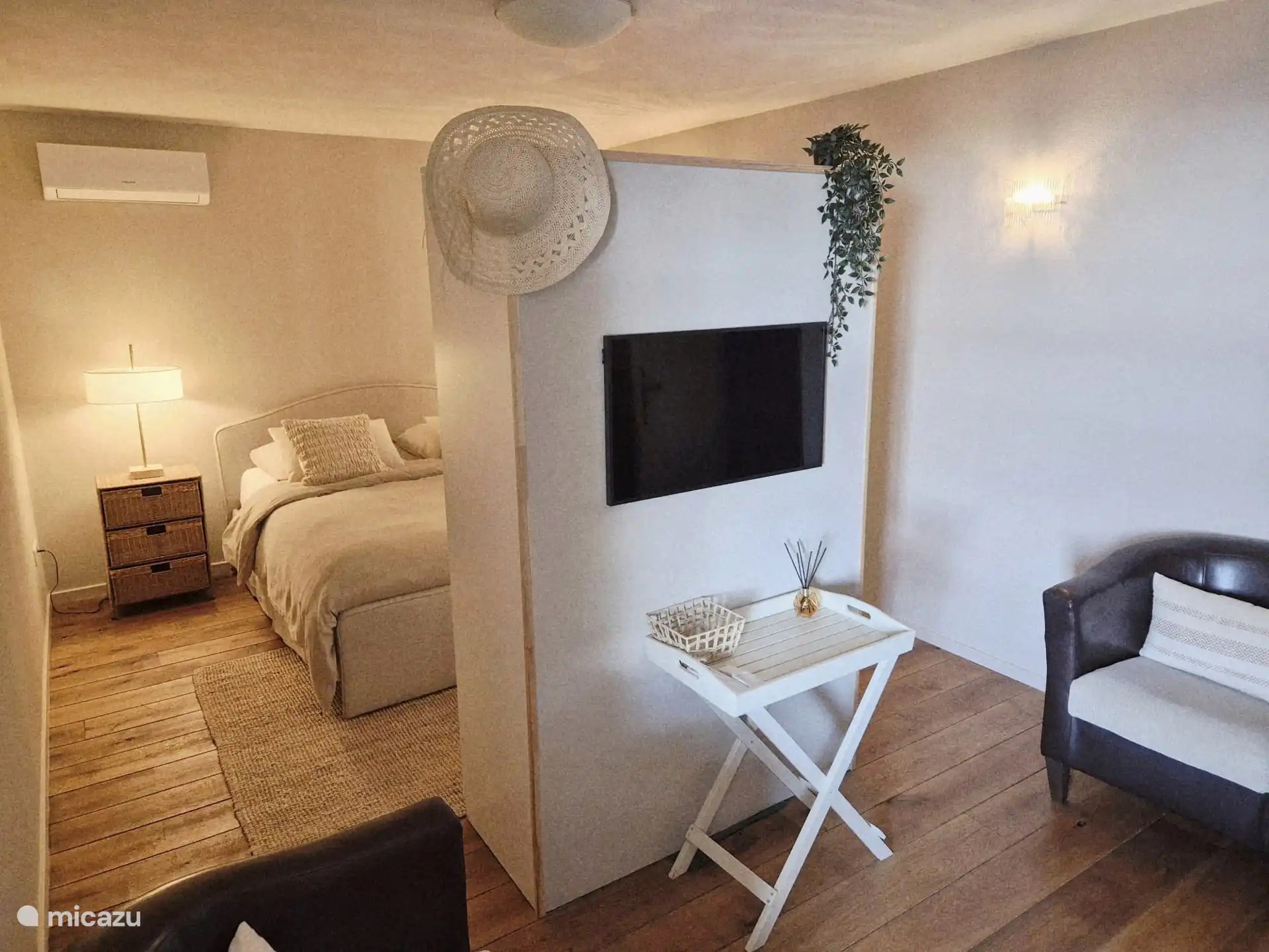 Studio au sous-sol avec sièges, placard et télévision.