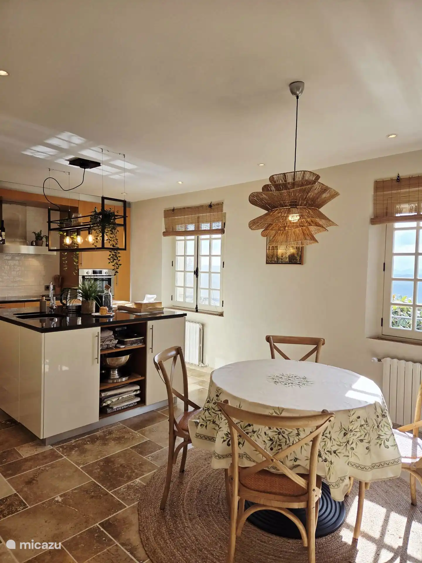 Keuken met ronde eettafel en twee ramen met uitzicht op vallei