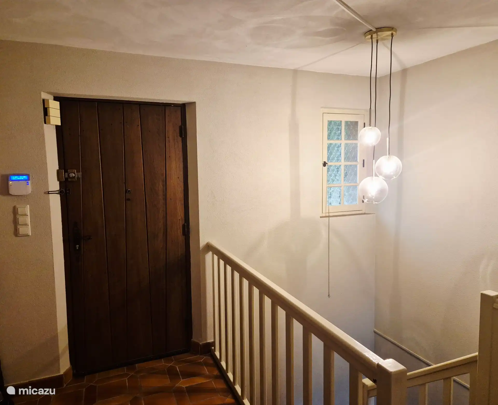 Porte d’entrée et couloir avec escaliers menant au sous-sol