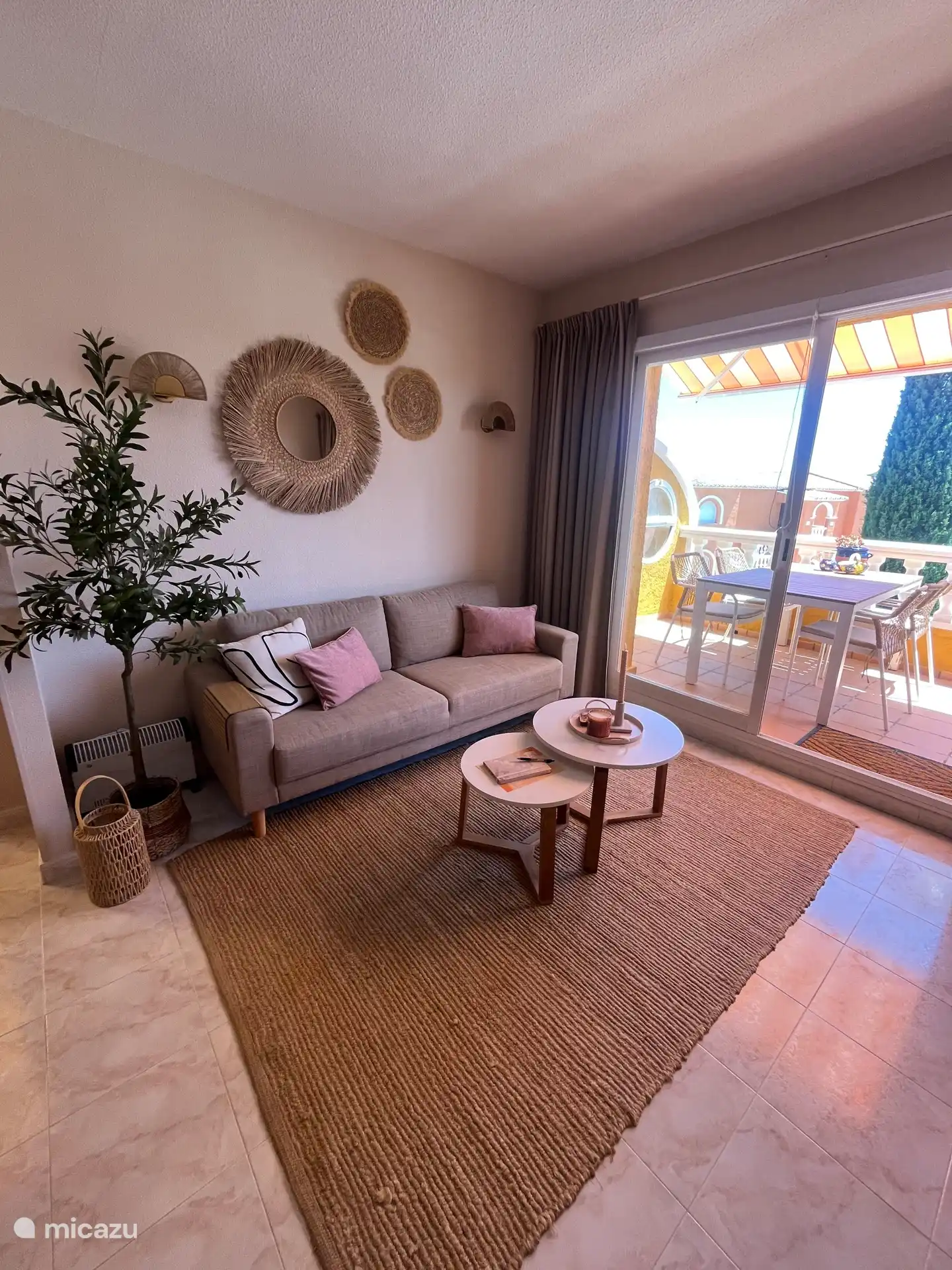 Woonkamer met aangrenzend balkon met tuinset en 4 stoelen. Uitzicht op zee en padelbaan.