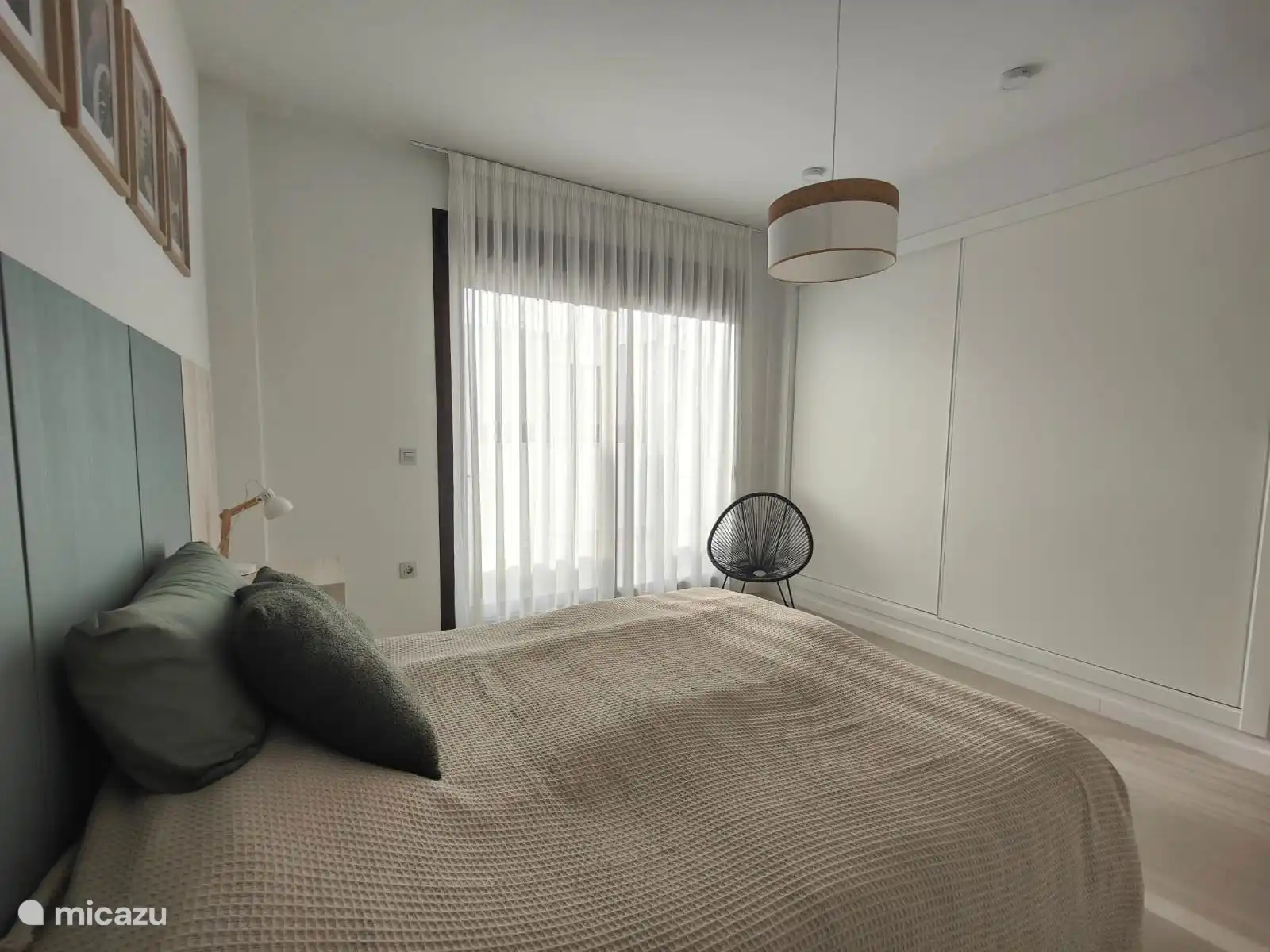 slaapkamer op 1e verdieping met grote kasten en toegang tot balkon