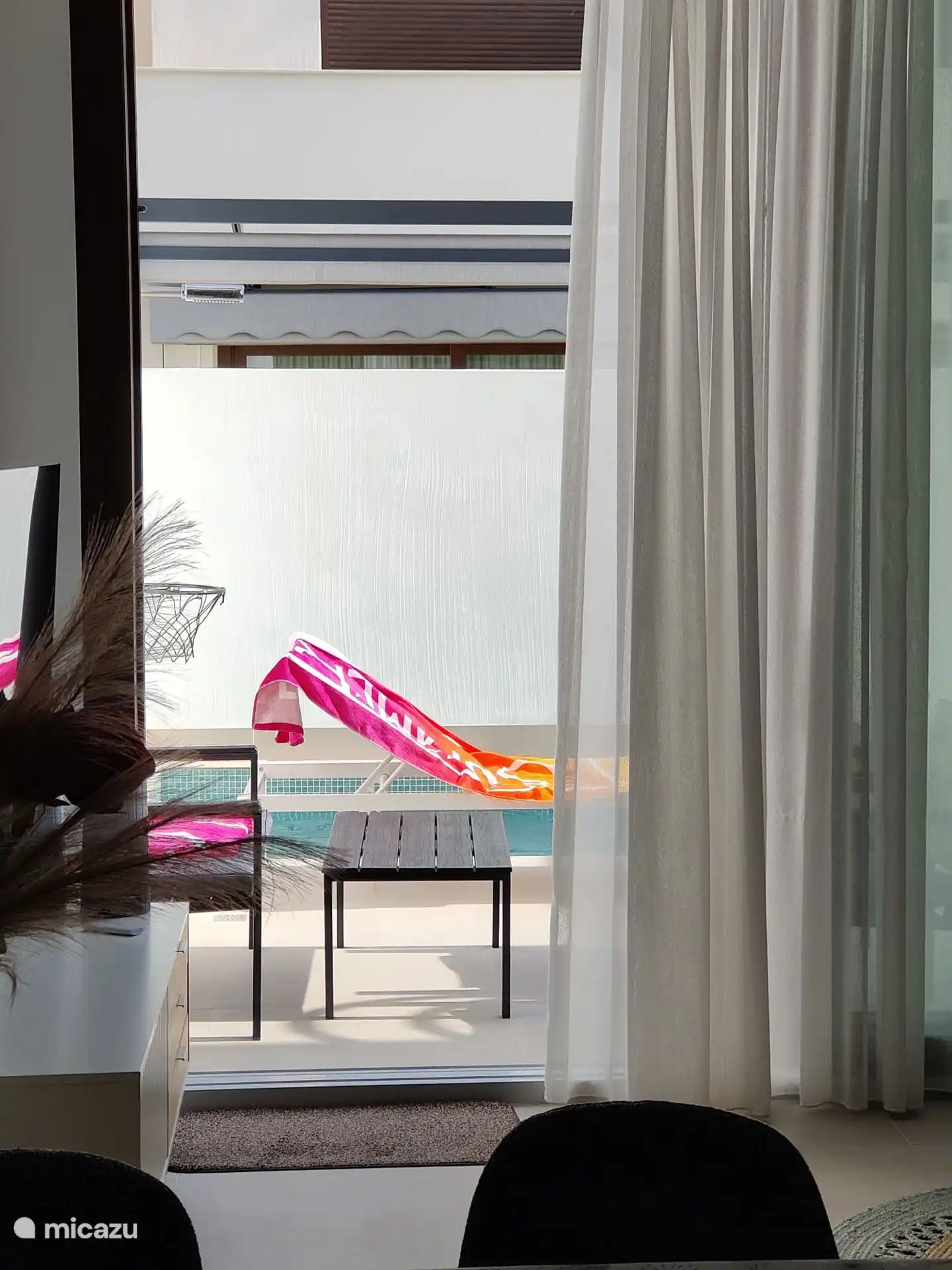 via de open schuifpui zicht op het terras met zwembad