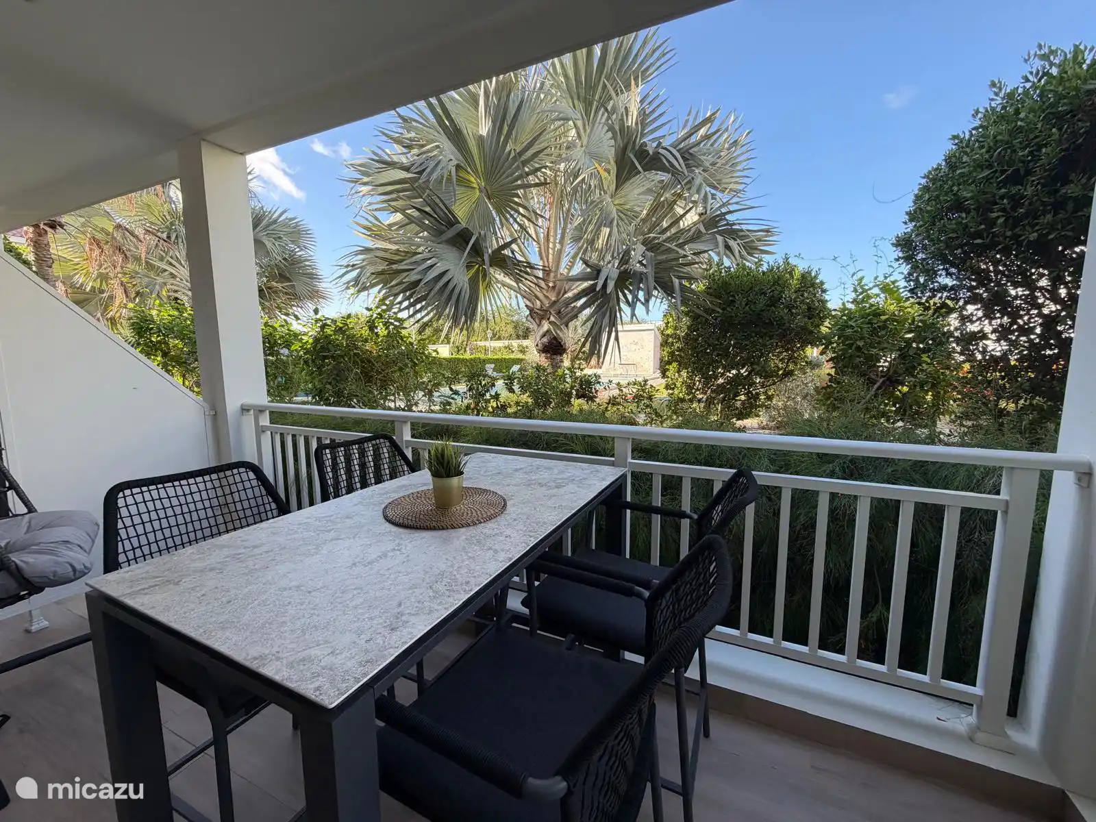 Pórtico con mesa de bar y vistas al jardín y a la piscina
