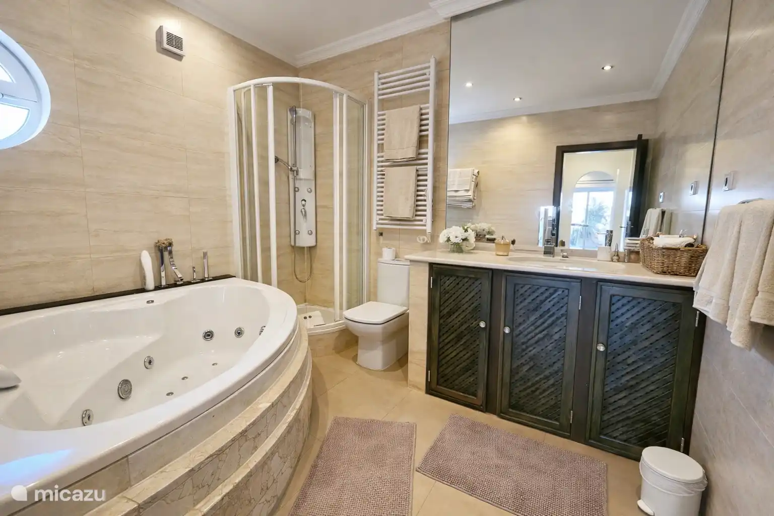 Badkamer 1 met bubbelbad, douche, toilet en wastafel.