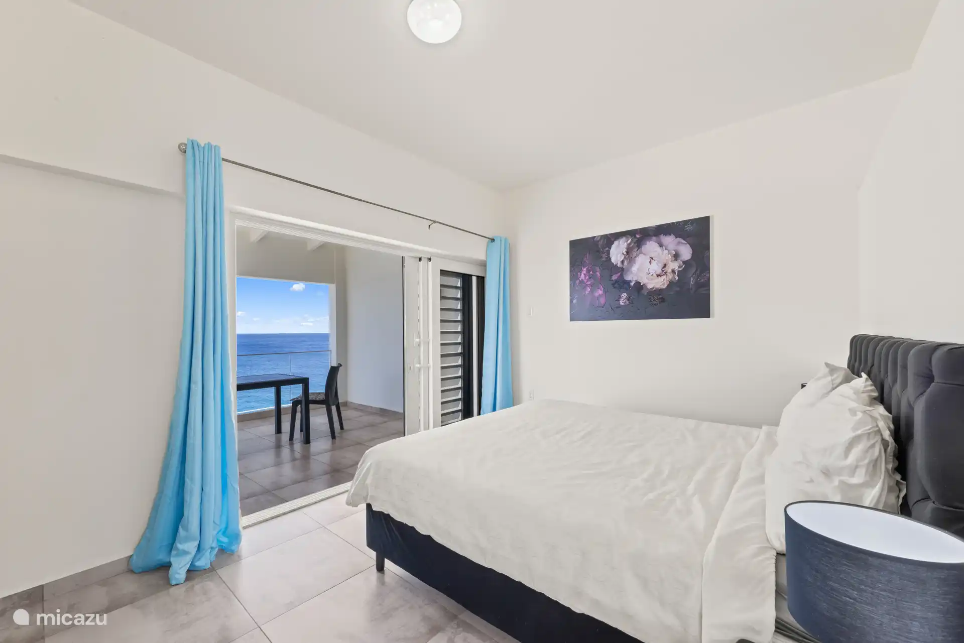 Chambre parentale avec balcon privé et vue sur la mer.