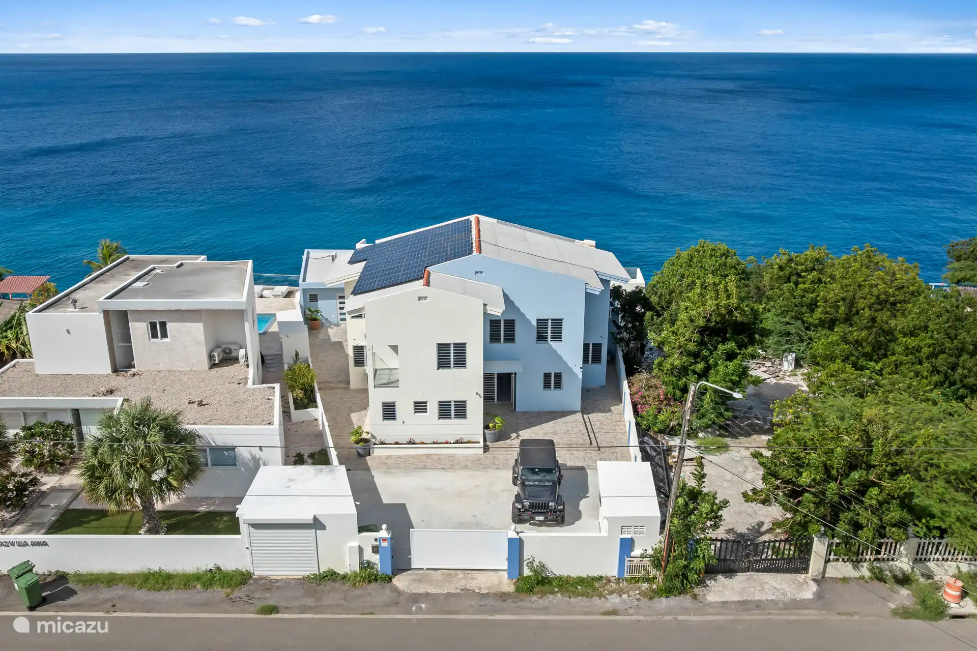 Vue de face sur le complexe, parking à l’intérieur de la porte.