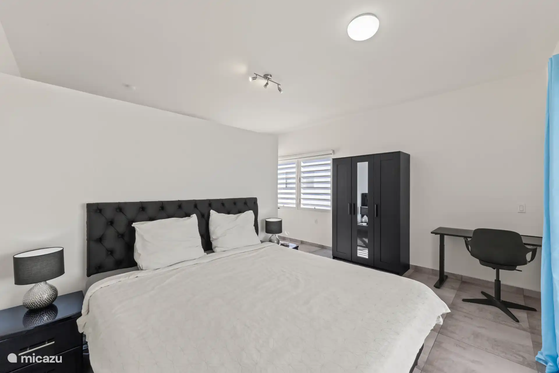 Chambre principale au rez-de-chaussée, avec bureau et armoire.