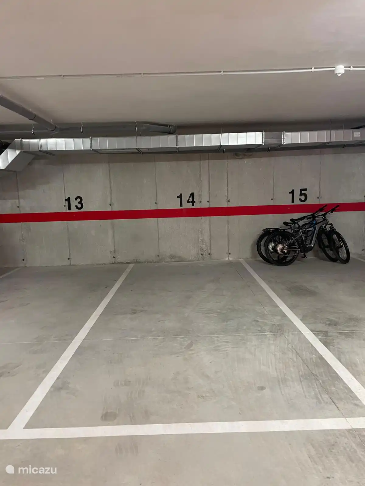 Grote parkeerplaats waar een auto met daarachter fietsen kunnen worden geparkeerd