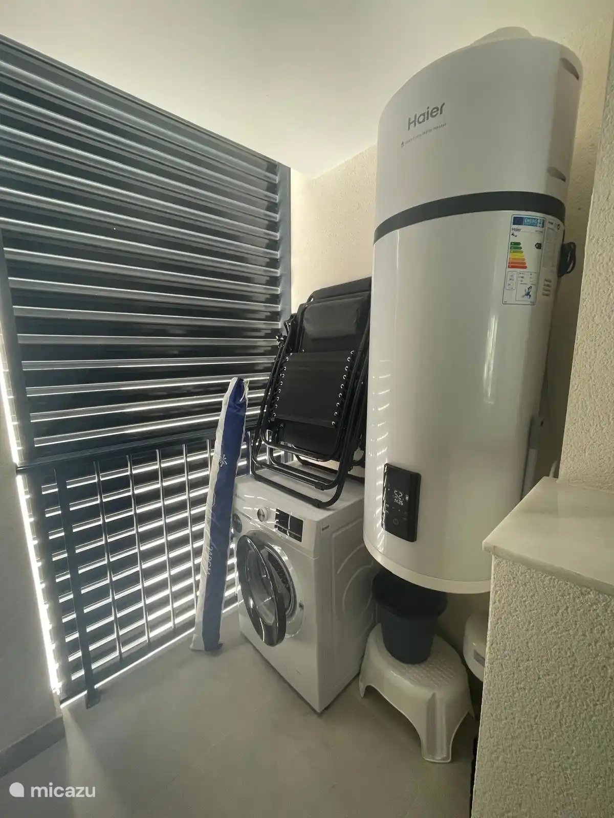 Bijkeuken met wasmachine en strandstoelen om mee te nemen naar het strand