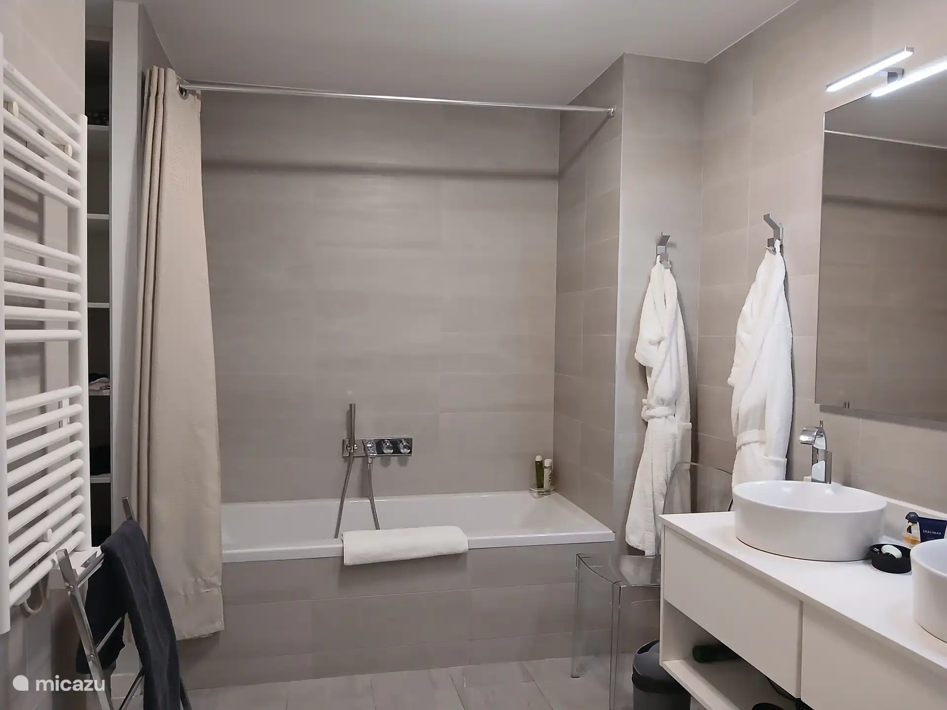 Hoofdslaapkamer badkamer met dubbele wastafels en bad