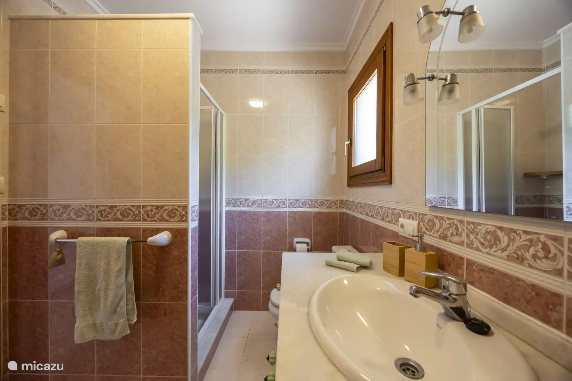 Das Badezimmer verfügt über eine Badewanne, eine separate Dusche, ein Waschbecken und eine Toilette.