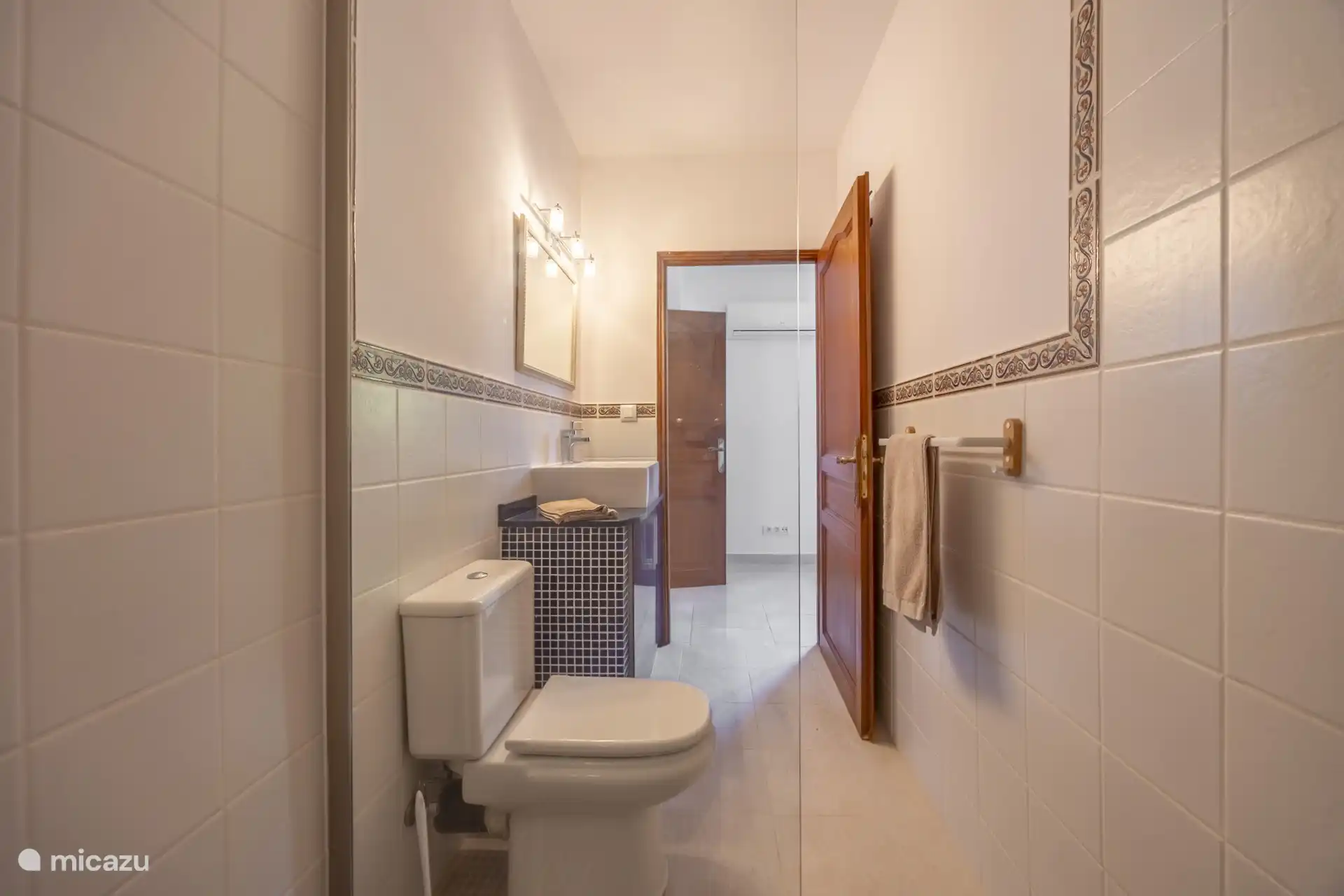 Das Badezimmer verfügt über Dusche, Waschbecken und Toilette.