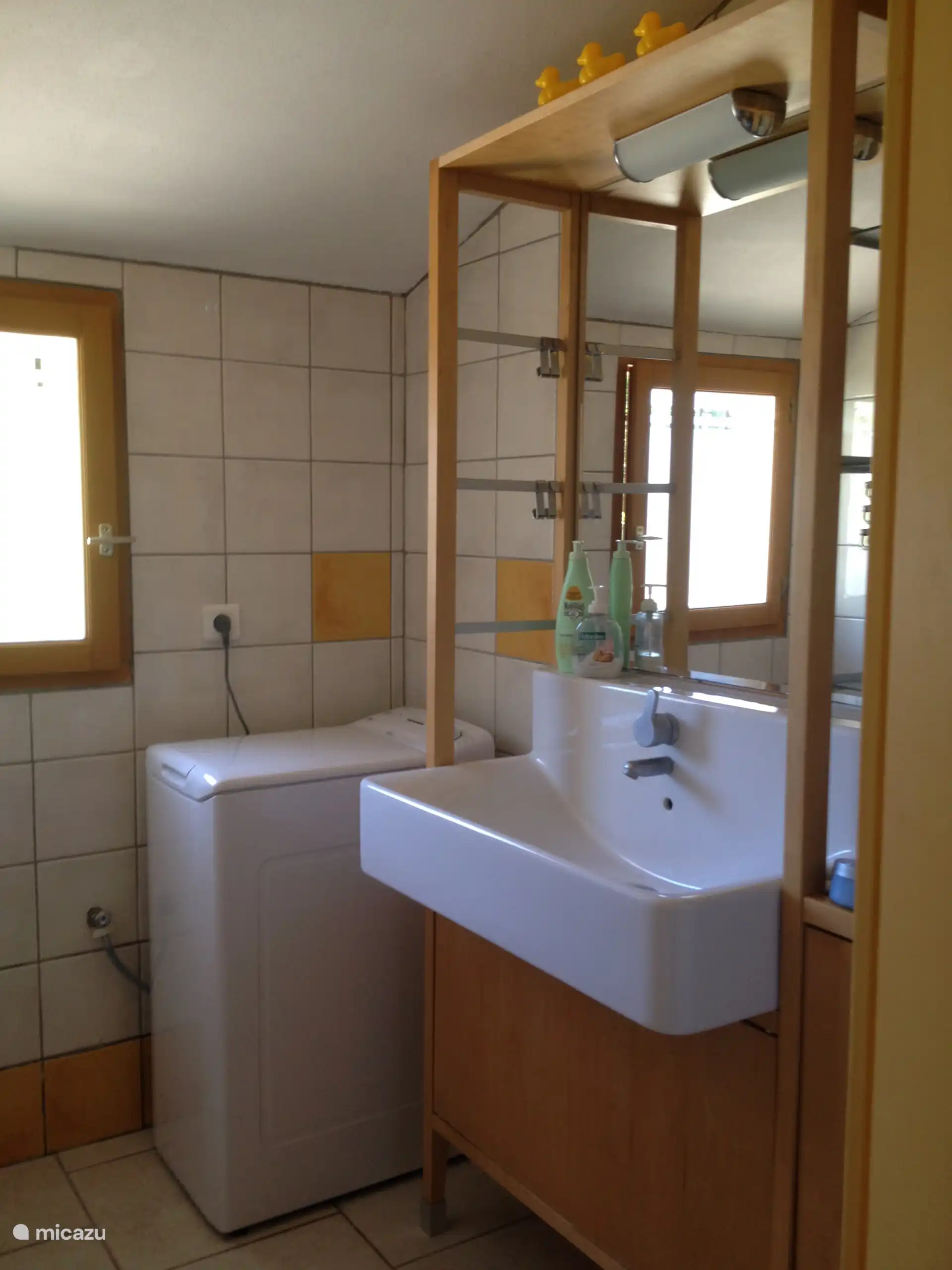bathroom with double showers, washing machine and sink