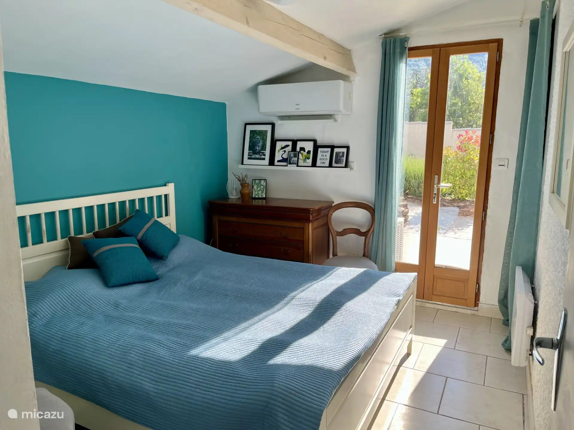 Slaapkamer voorkant met openslaande terrasdeuren (& hor) naar de tuin; airco 