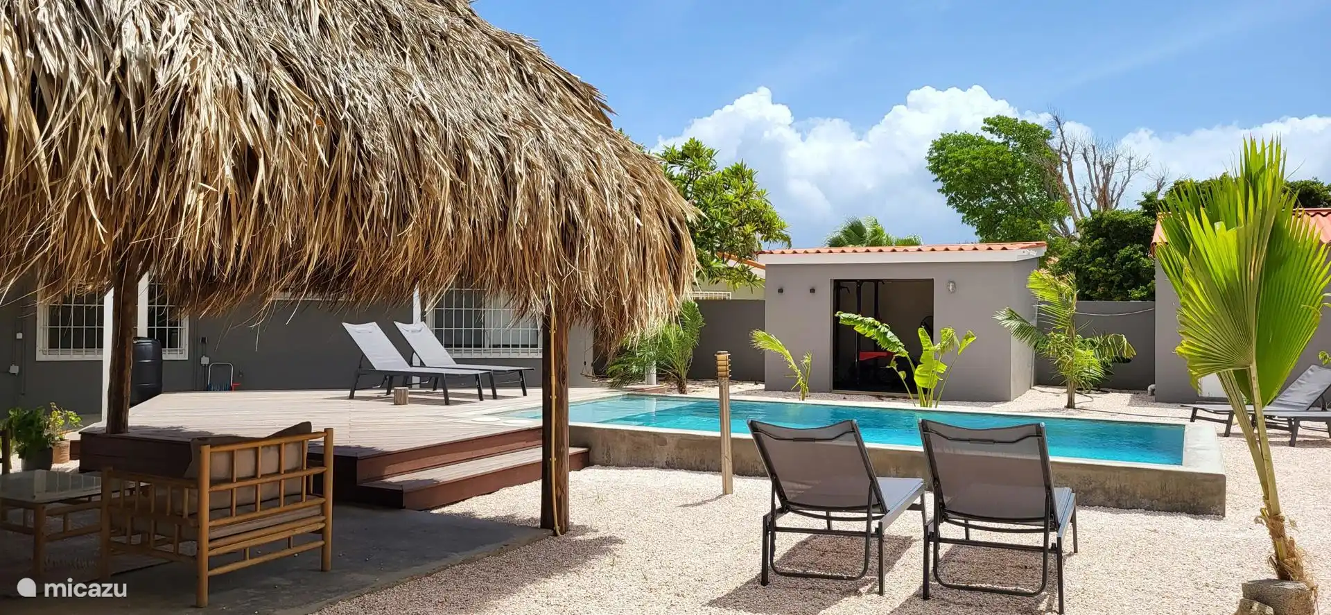 Achter het zwembad zie je de fitness ruimte, waar je al je oefeningen kan doen. Bokszak, Powerrack, gewichten. 