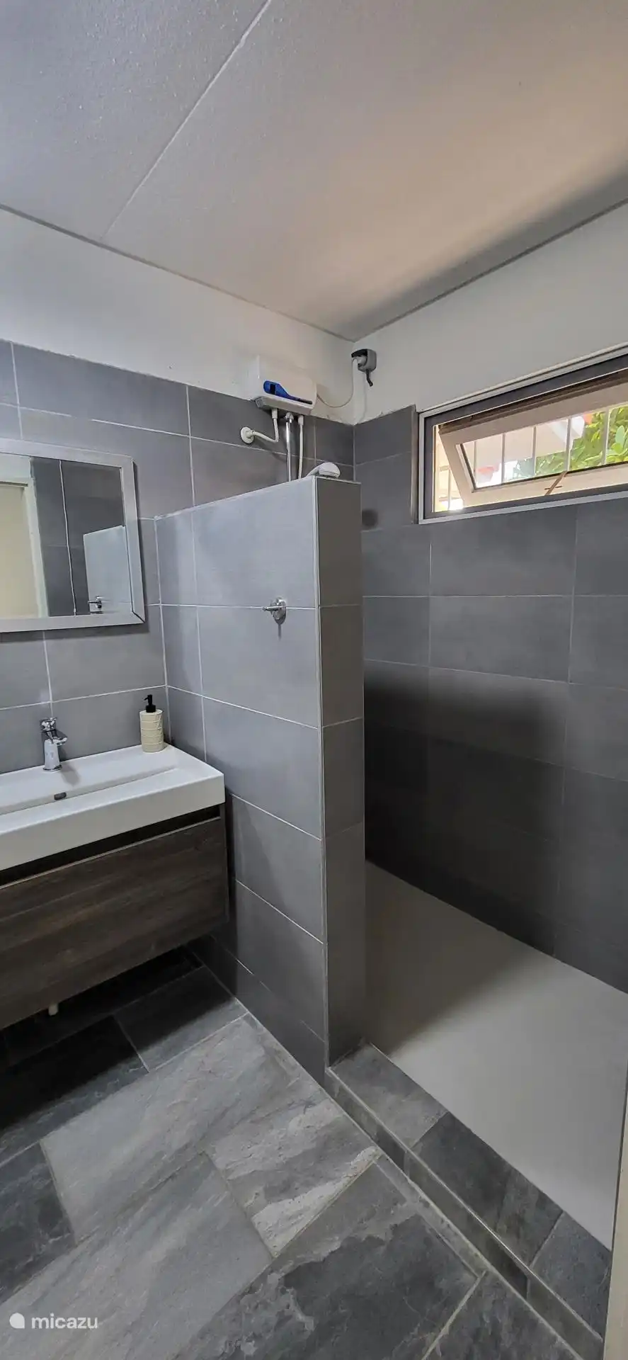 2 gelijke badkamers met wastafel, warme douche en toillet.