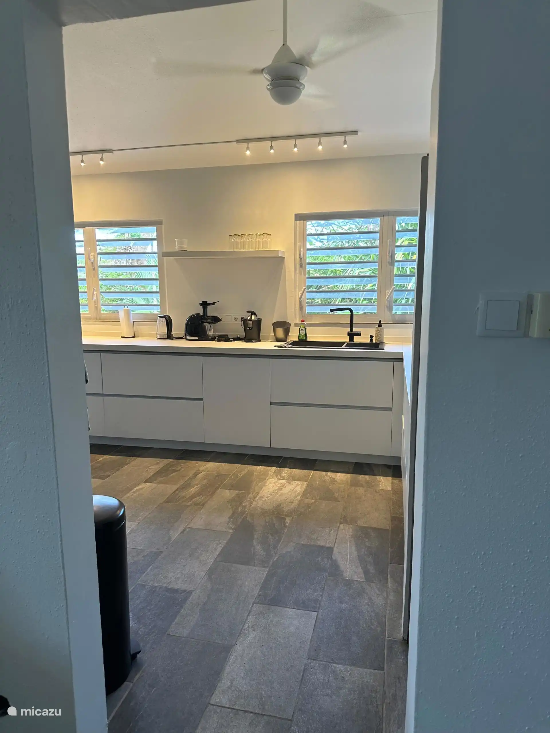 Vanuit de woonkamer loop je de keuken in. In de keuken heb je veel ramen met een groen uitzicht op de tuin aan de voorkant.