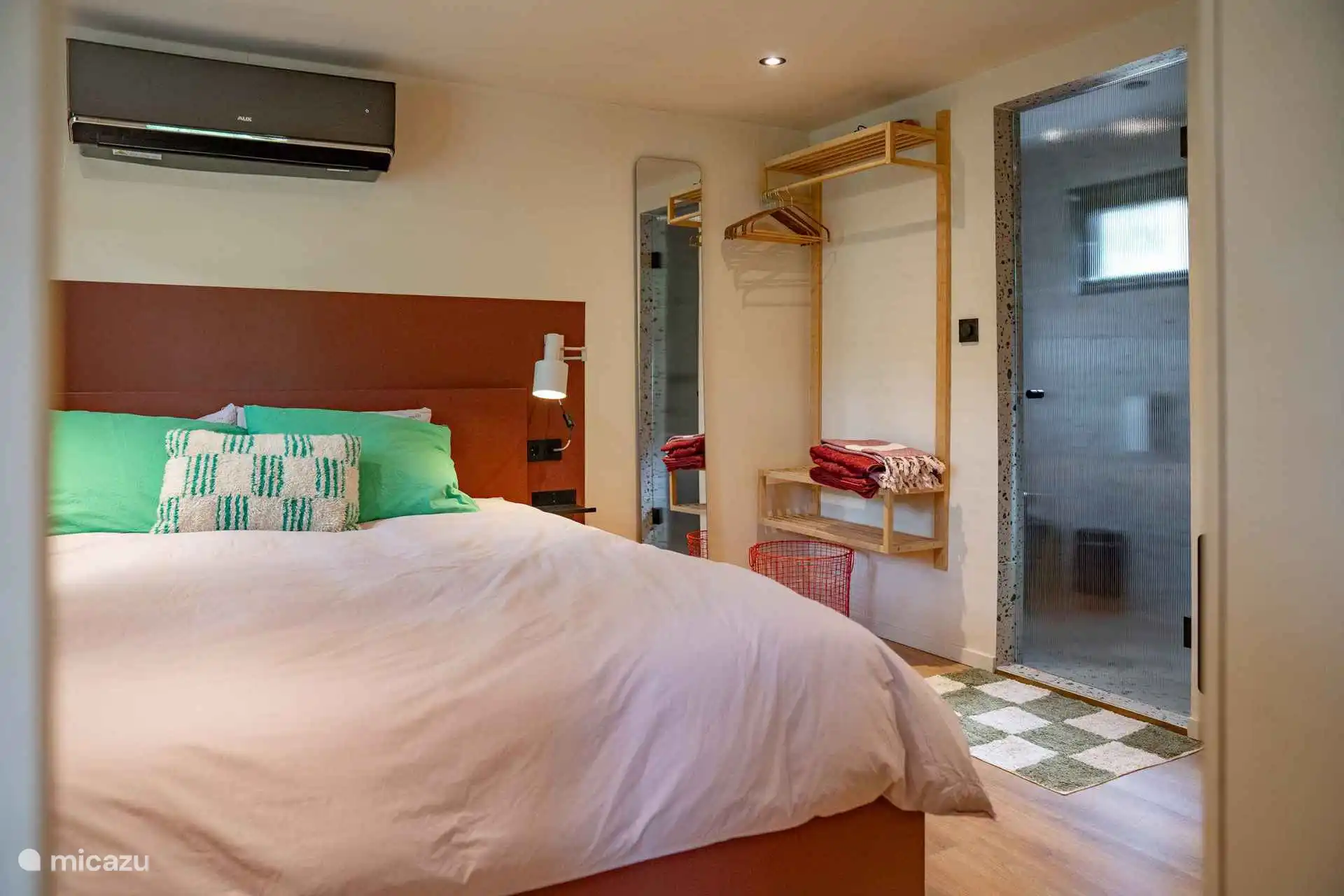 La chambre avec salle de bain attenante et climatisation. 