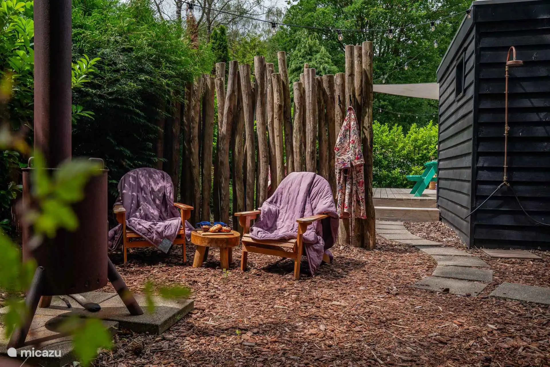 Deux espaces confortables avec un poêle et une vue sur la forêt.