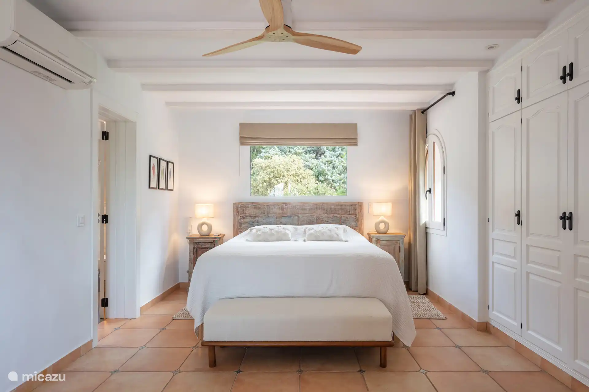 Bright bedroom with air conditioning and ensuite bathroom.