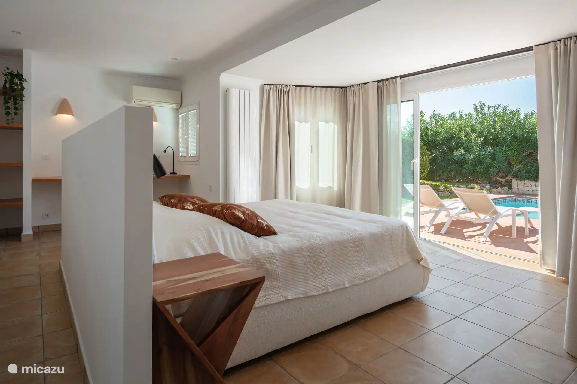 Bedroom adjacent to terrace with swimming pool.