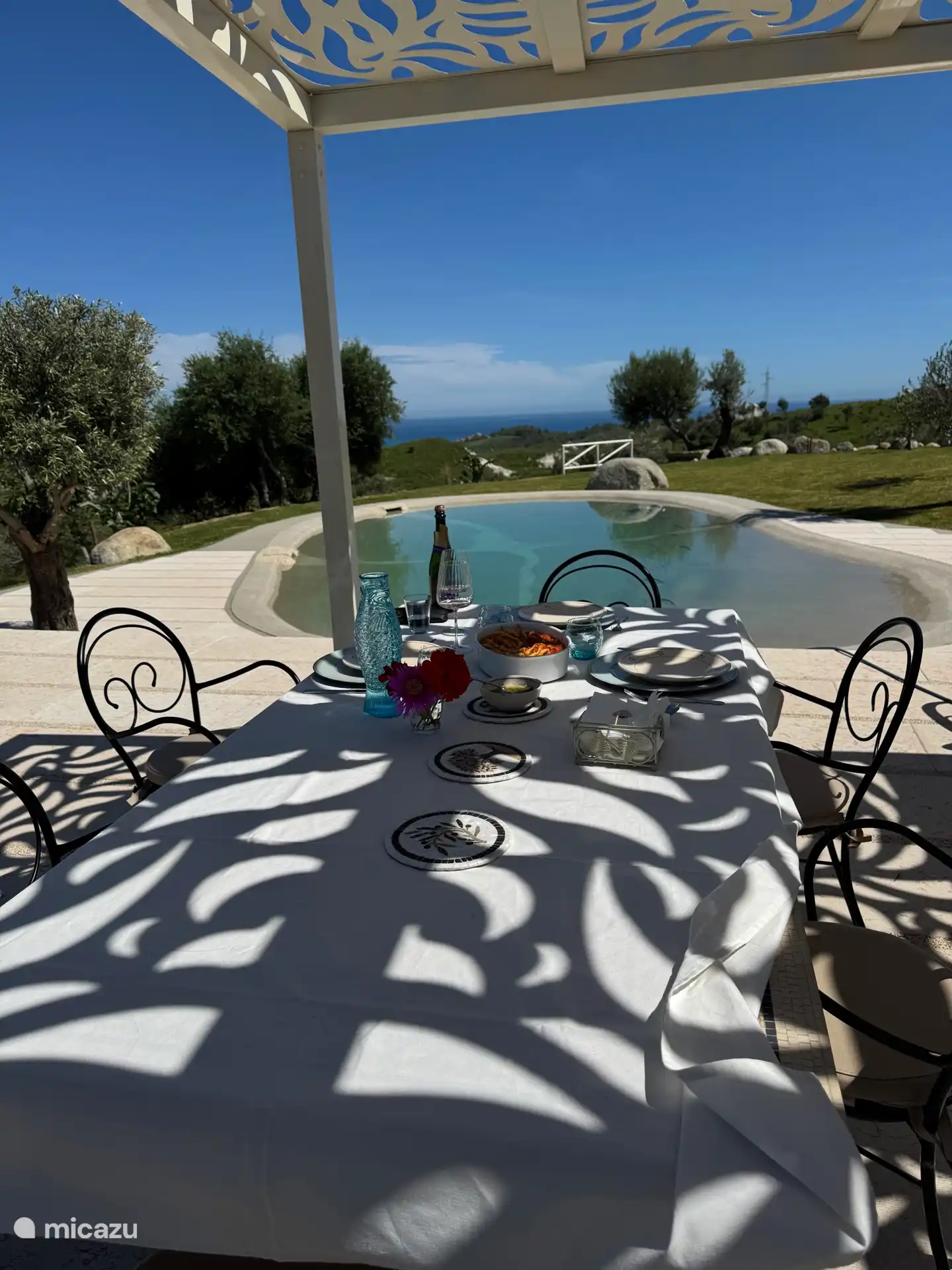 Raised terrace overlooking pool and sea.