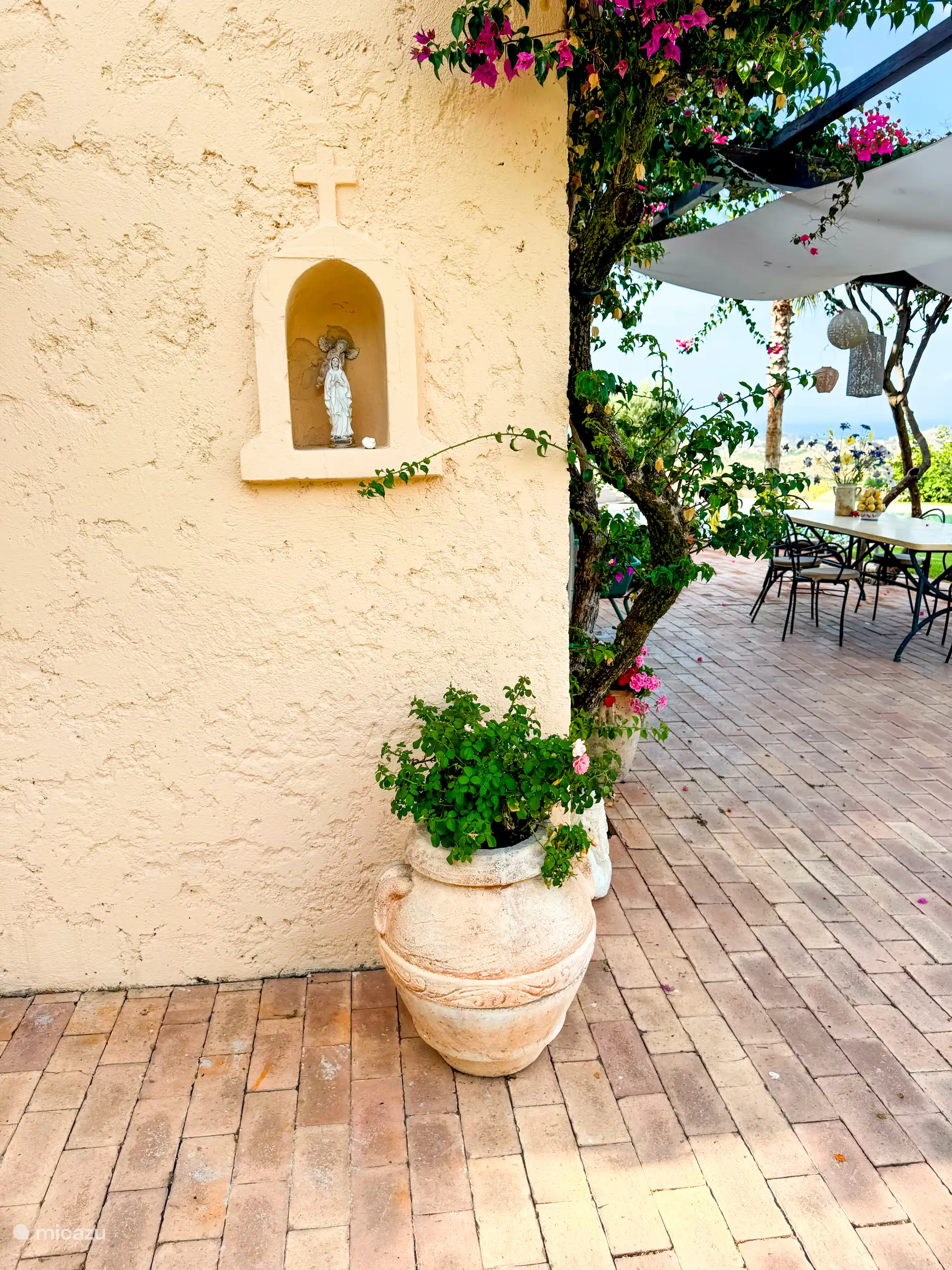Mediterrane details, terracotta, bloemen en uitzicht geven het terras karakter. Een warm beeld dat de Zuid-Italiaanse sfeer van de villa goed laat zien.