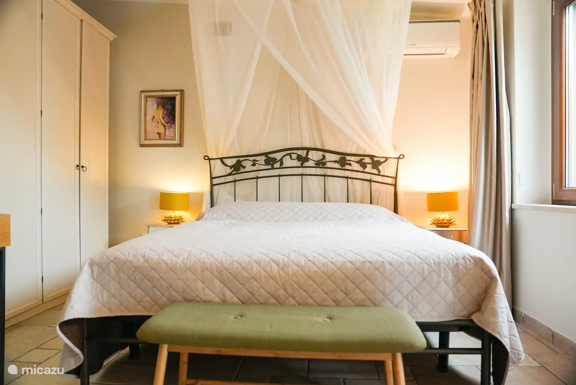 Slaapkamer 1 heeft een comfortabel tweepersoonsbed met lichte, zachte kleuren en airconditioning. Rustig ingericht voor een ontspannen nachtrust.