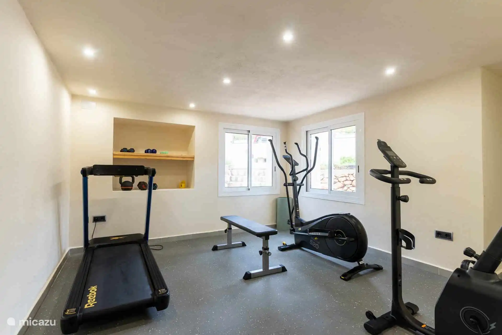 Ruime gym, met veel apparaten.