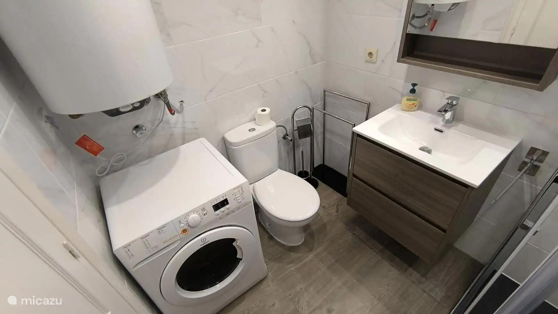 Doucheruimte met wasmachine. 