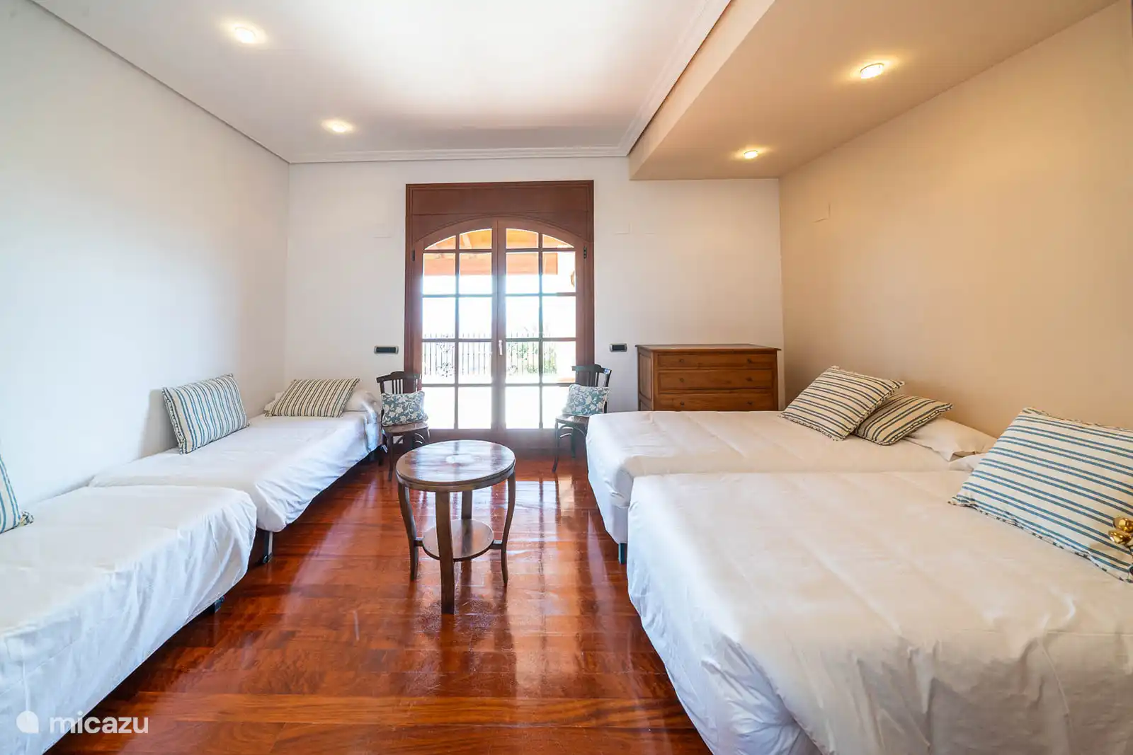 Chambre avec 4 lits simples, climatisation, accès terrasse avec vue sur le parc.