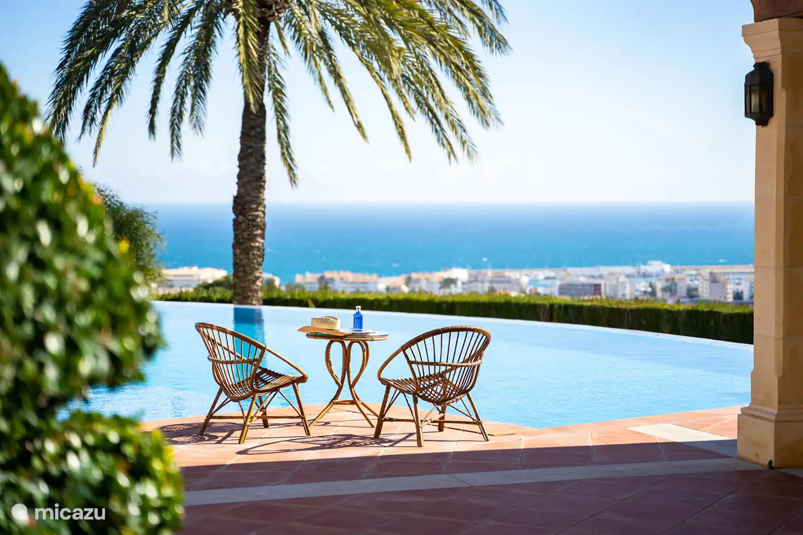 Belle et grande piscine, vue mer, terrasse avec chaises longues. Salon extérieur et lounge sur la terrasse couverte. 